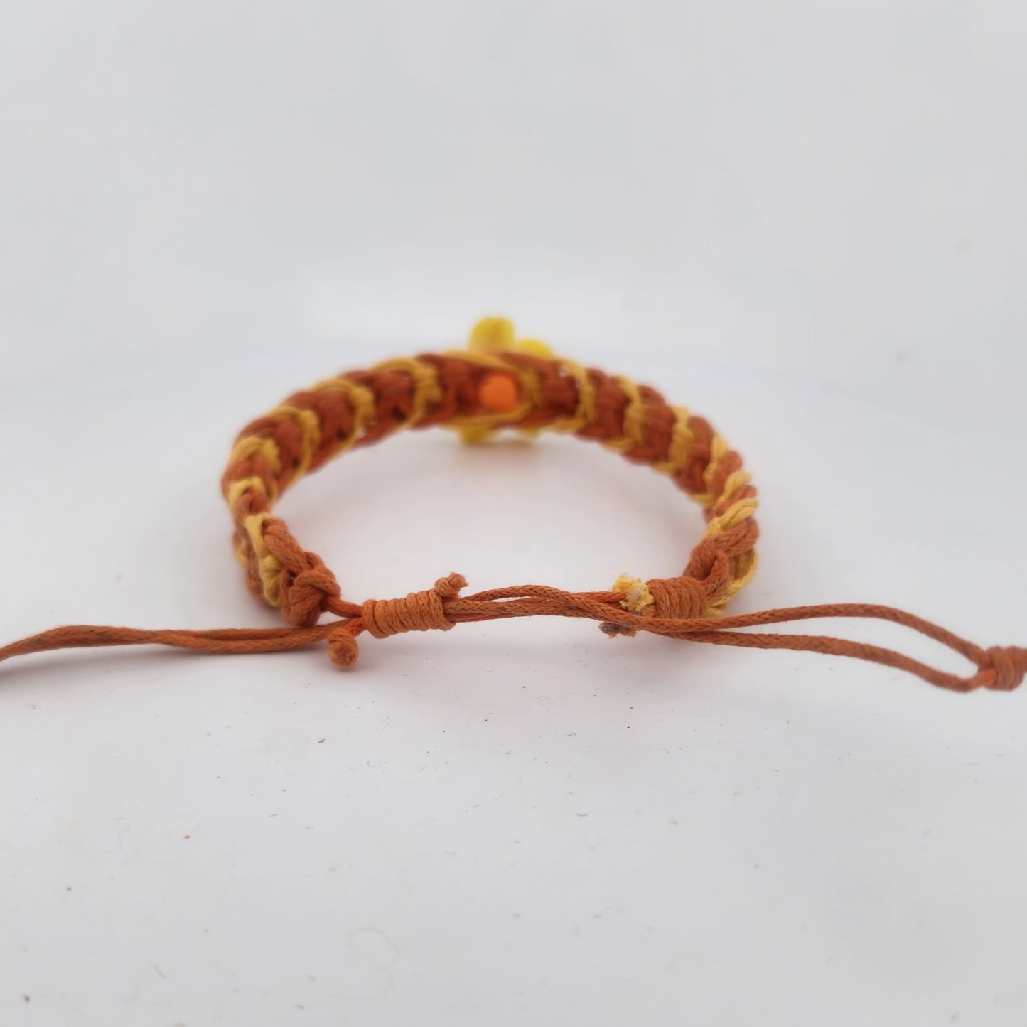 Brown braided bracelet on a light gray background