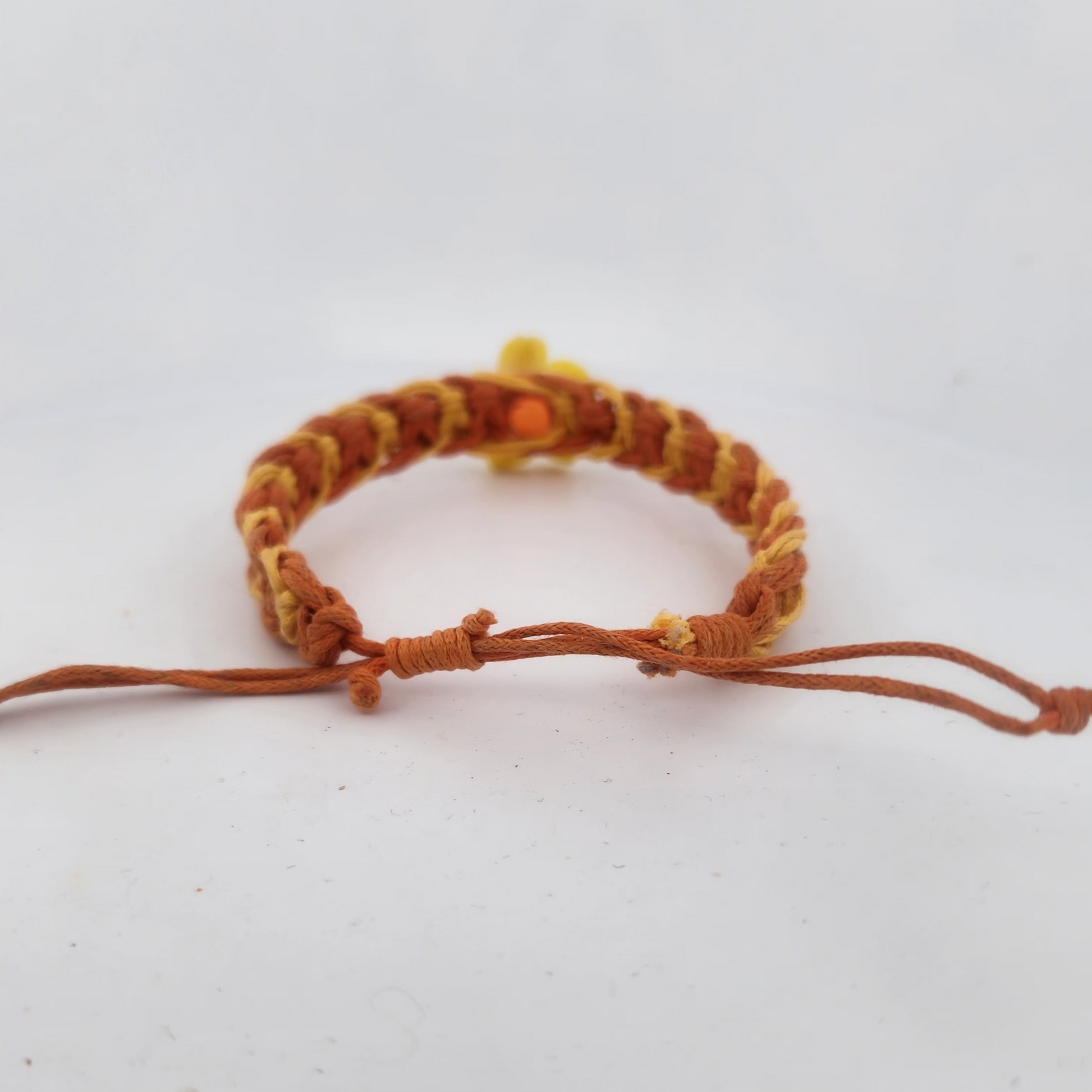 Brown braided bracelet on a light gray background