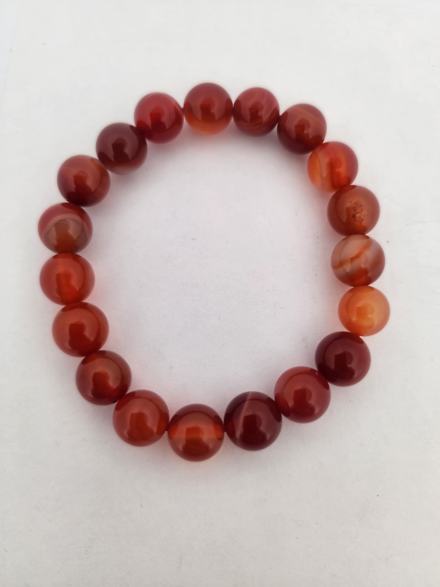 Beaded bracelet with red and orange beads on a white background