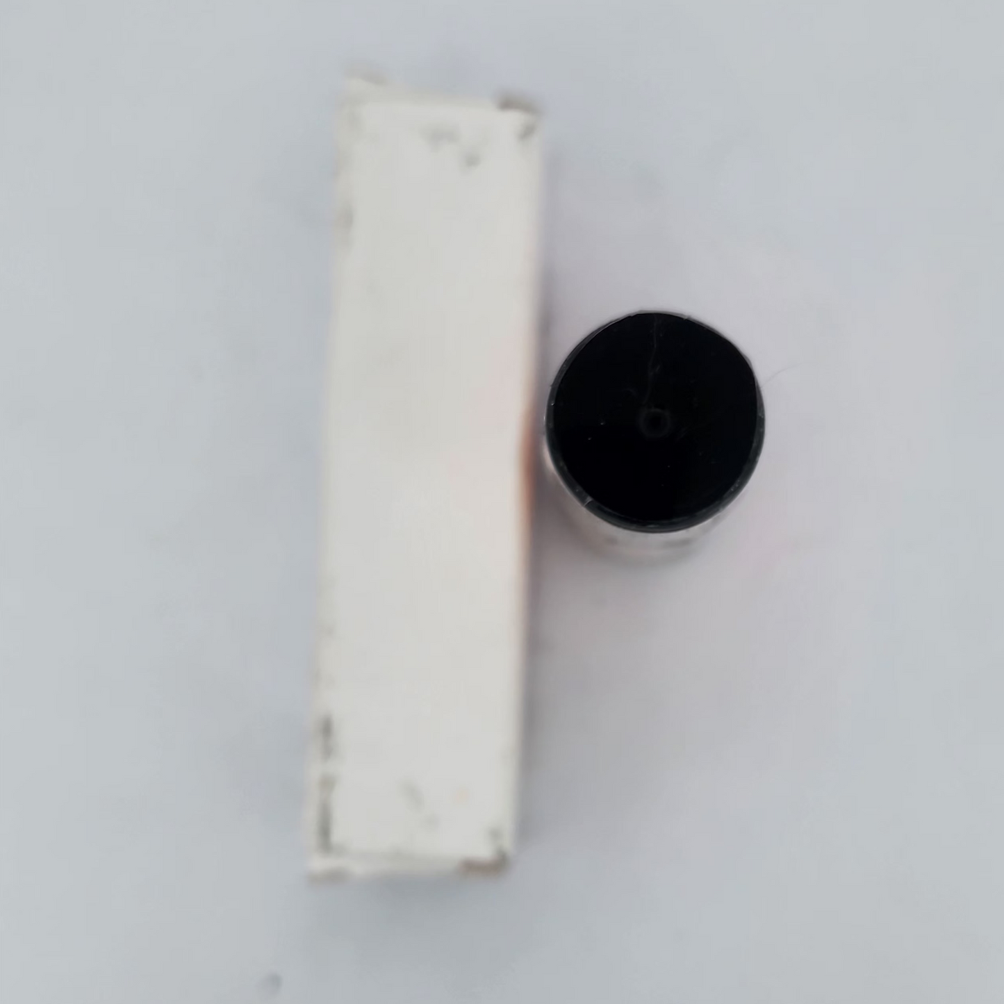 Two cylindrical objects on a white surface