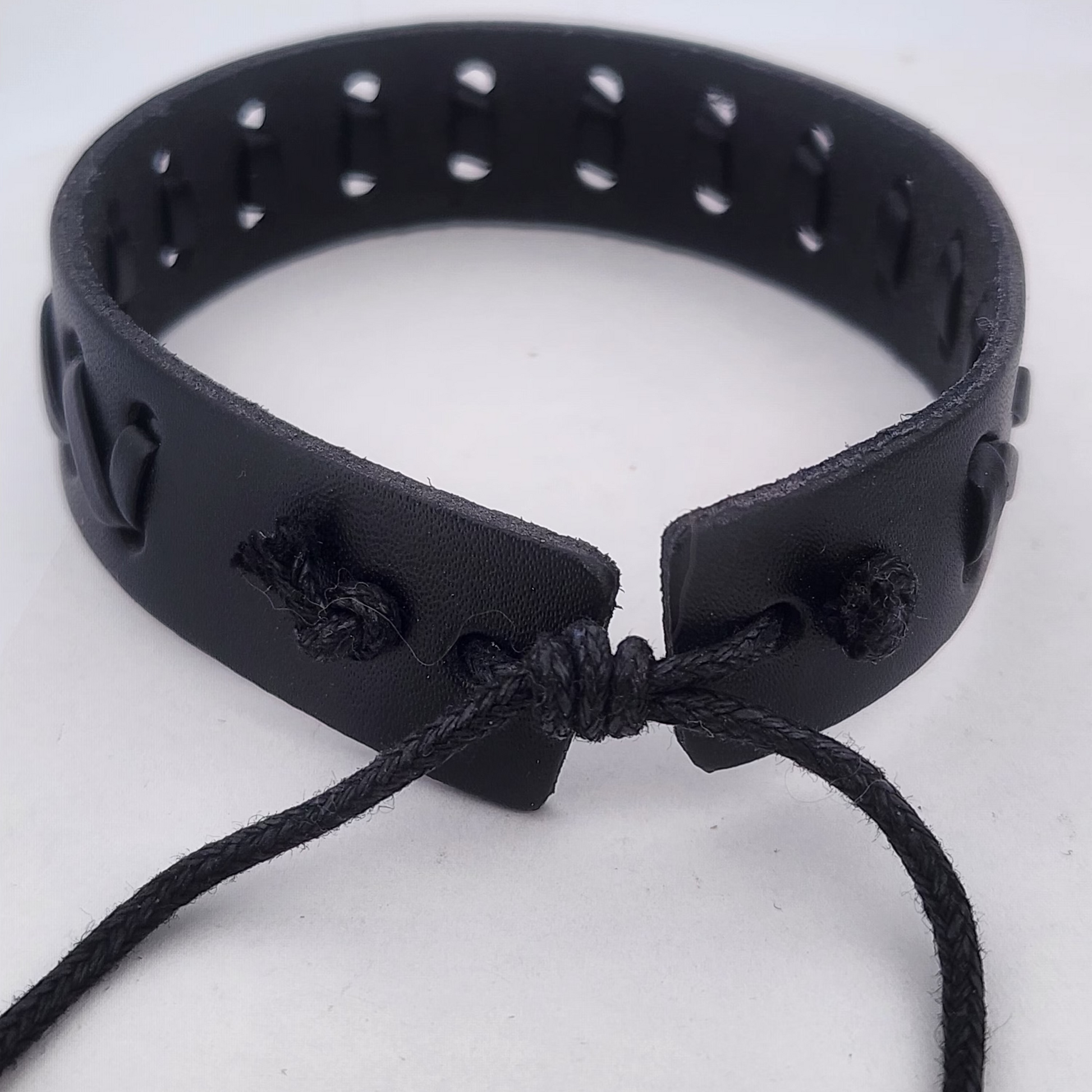 Black leather choker with a knotted design on a white background