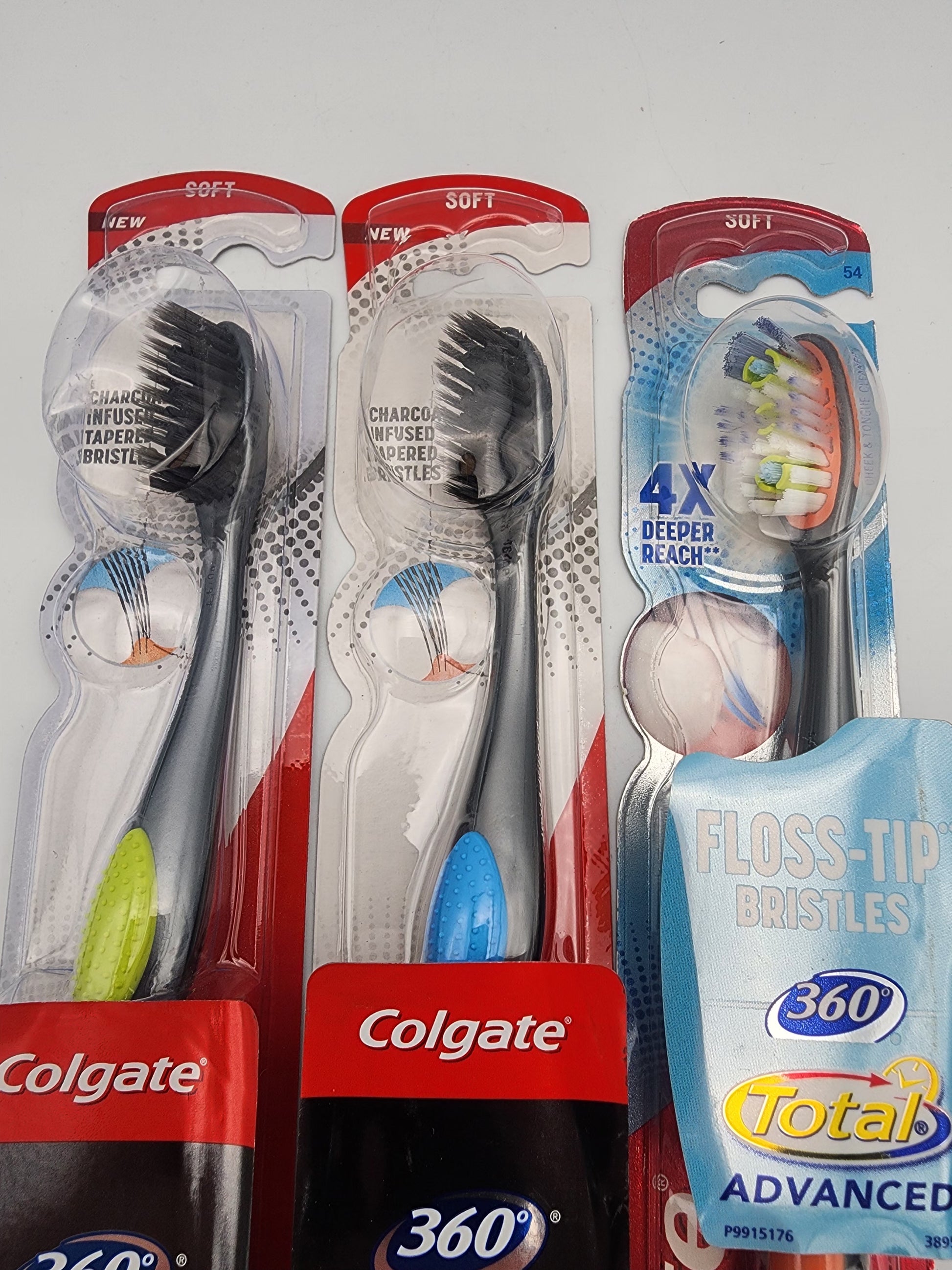 Three Colgate toothbrushes with packaging and a tube of 360 Total Advanced toothpaste on a white background.