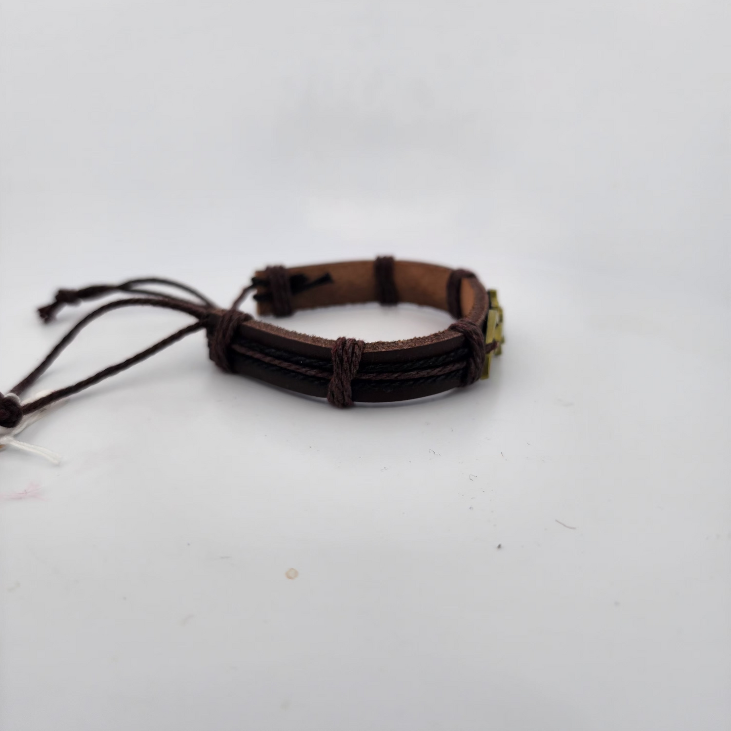 Brown leather bracelet with metal clasp on a white background
