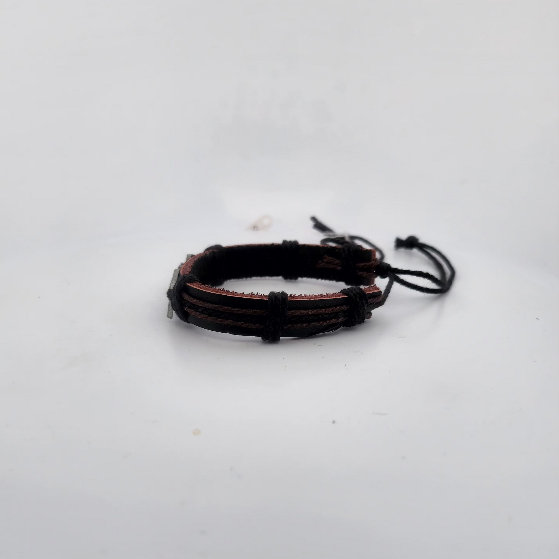 Bracelet with brown and black cord on a white background