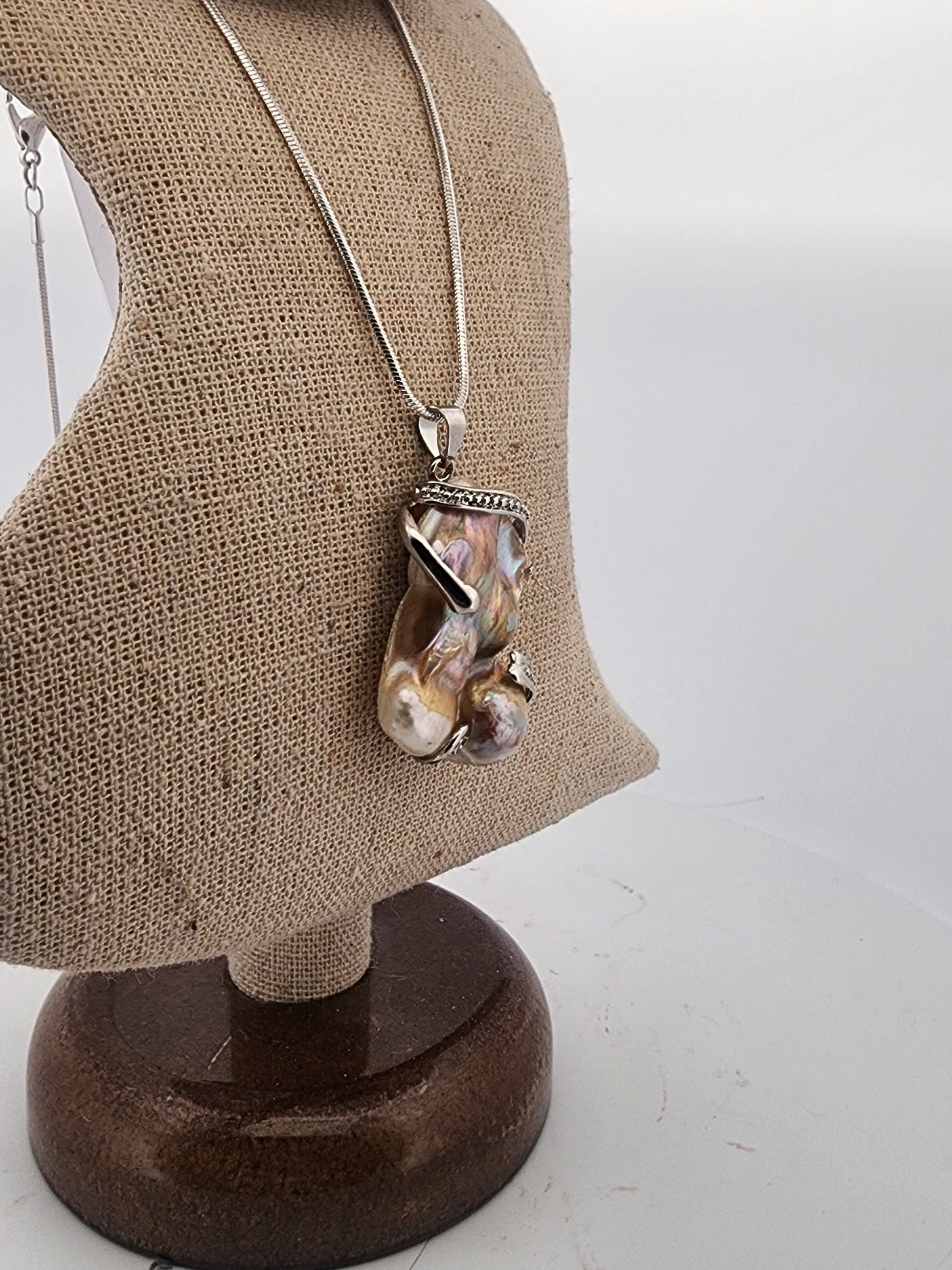 Necklace with a unique pendant on a mannequin bust against a white background