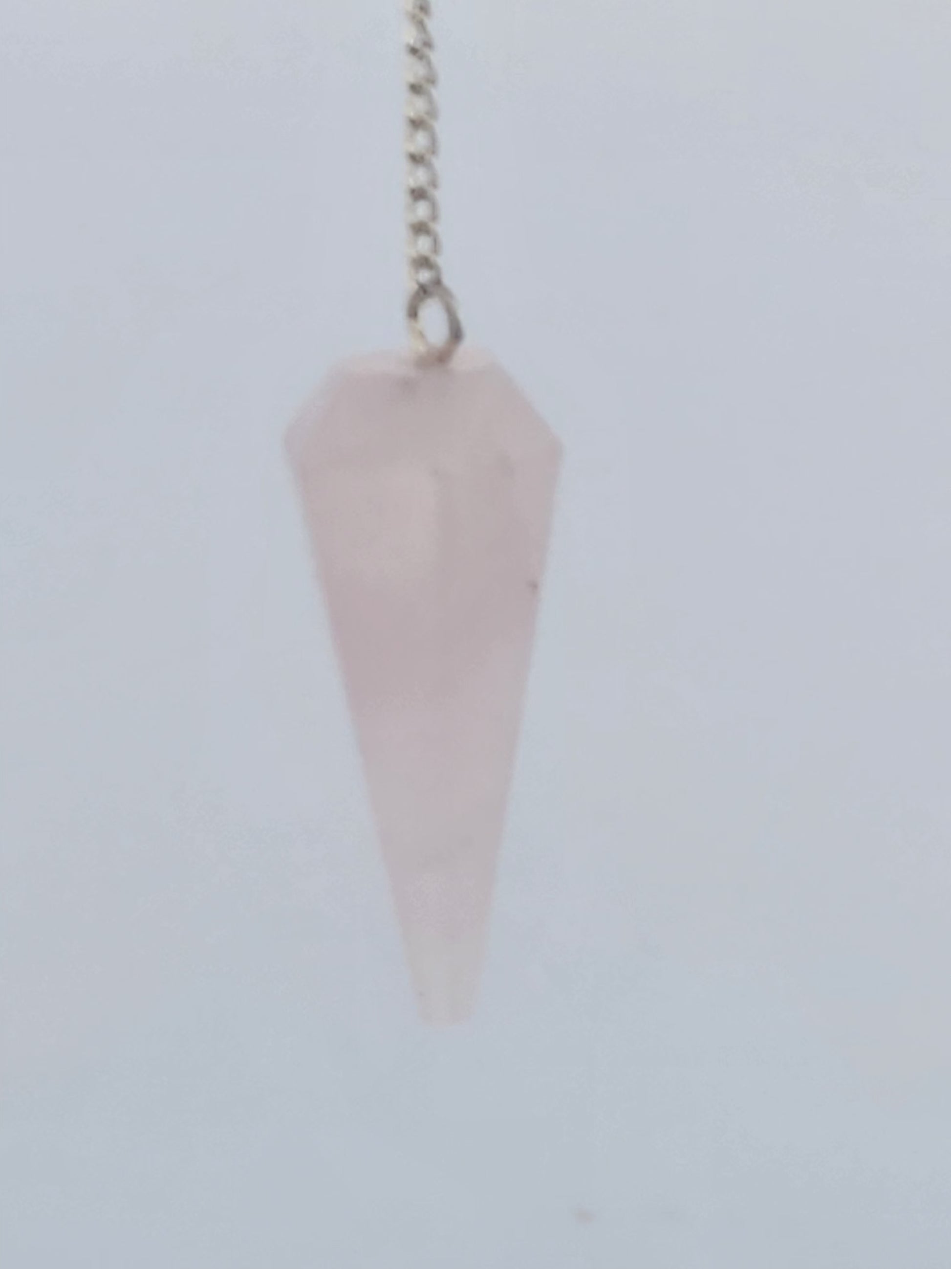 Pink crystal pendulum on a white background
