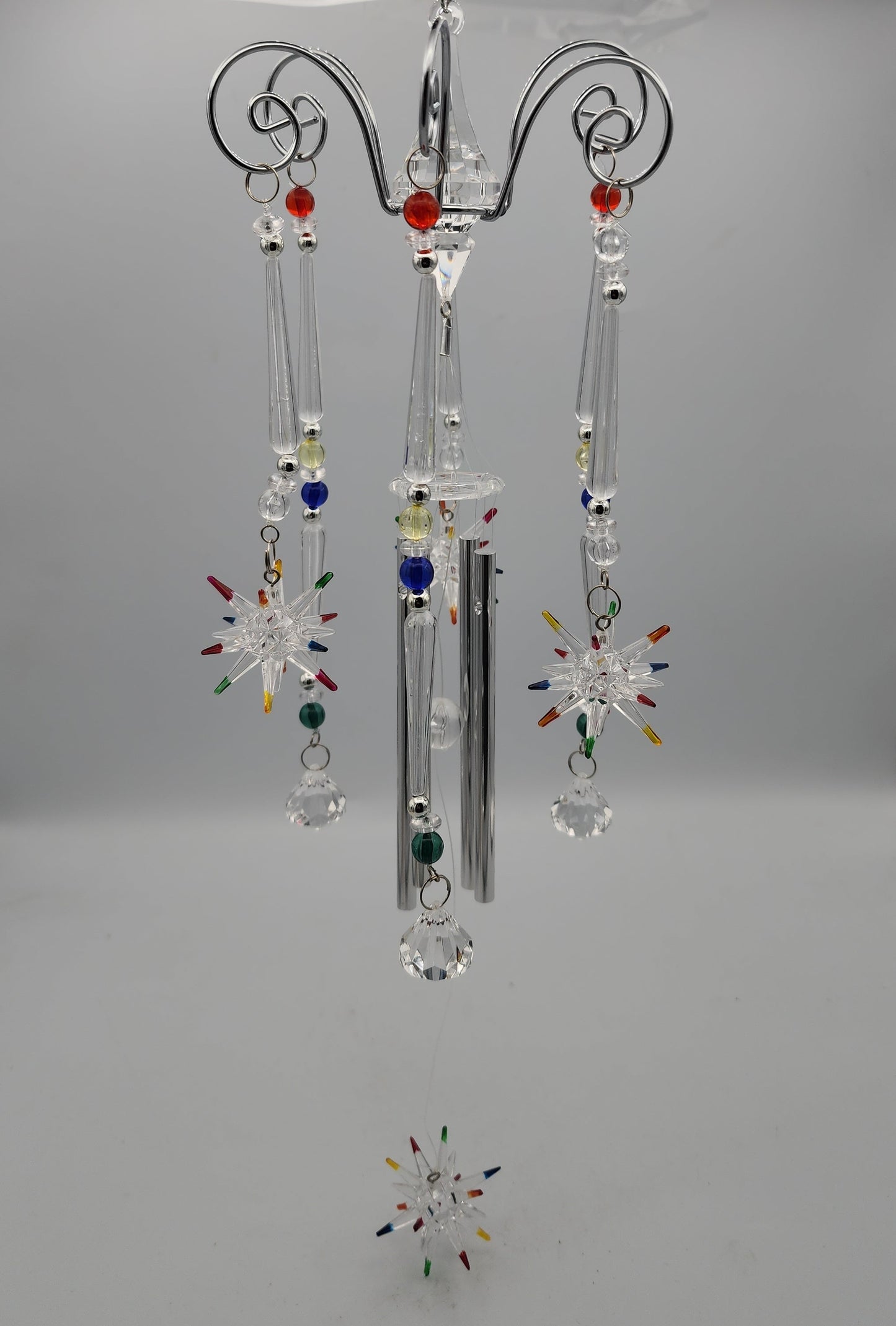 Decorative hanging crystal with colorful beads on a gray background