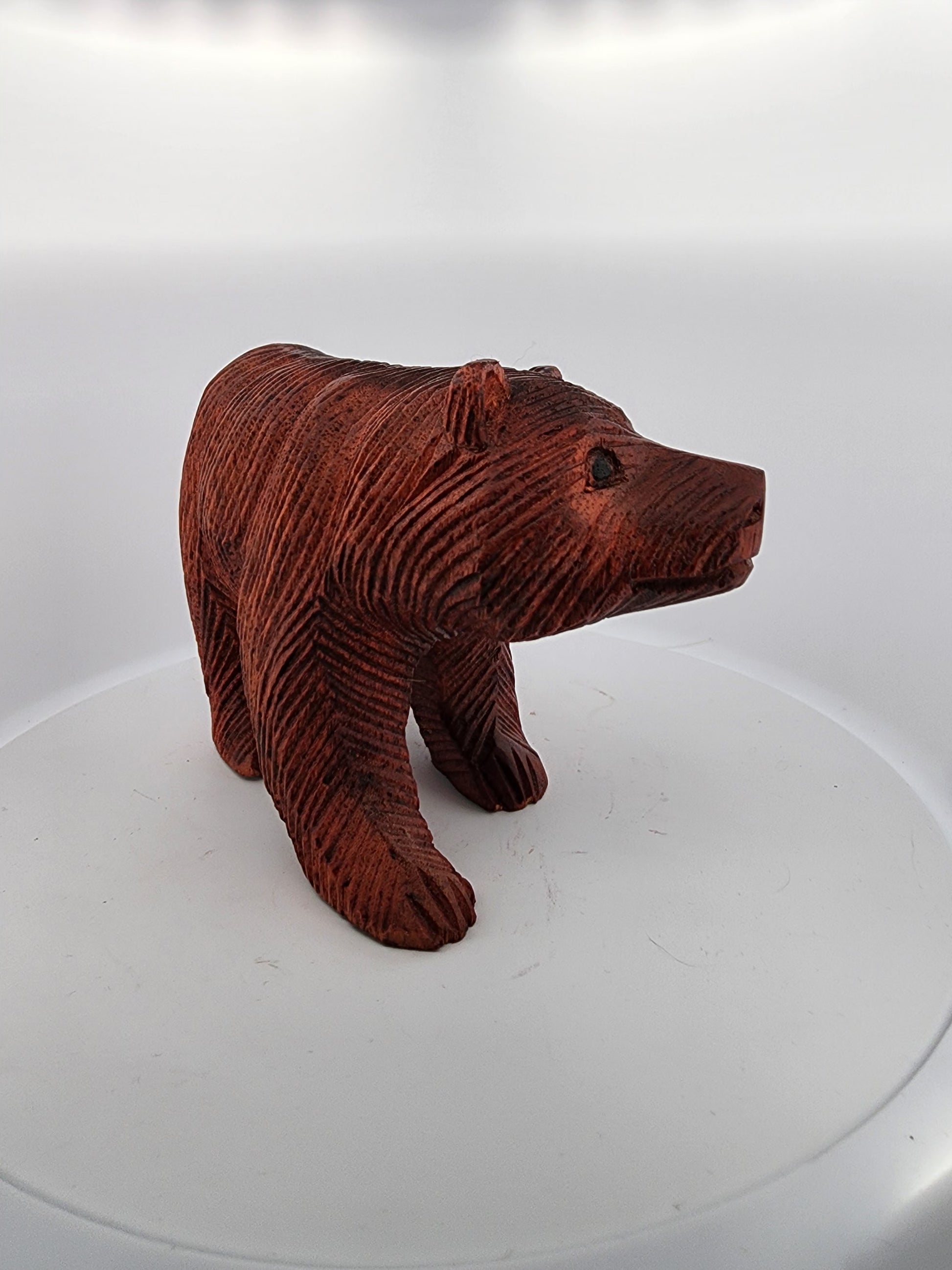 Brown bear figurine on a white platform