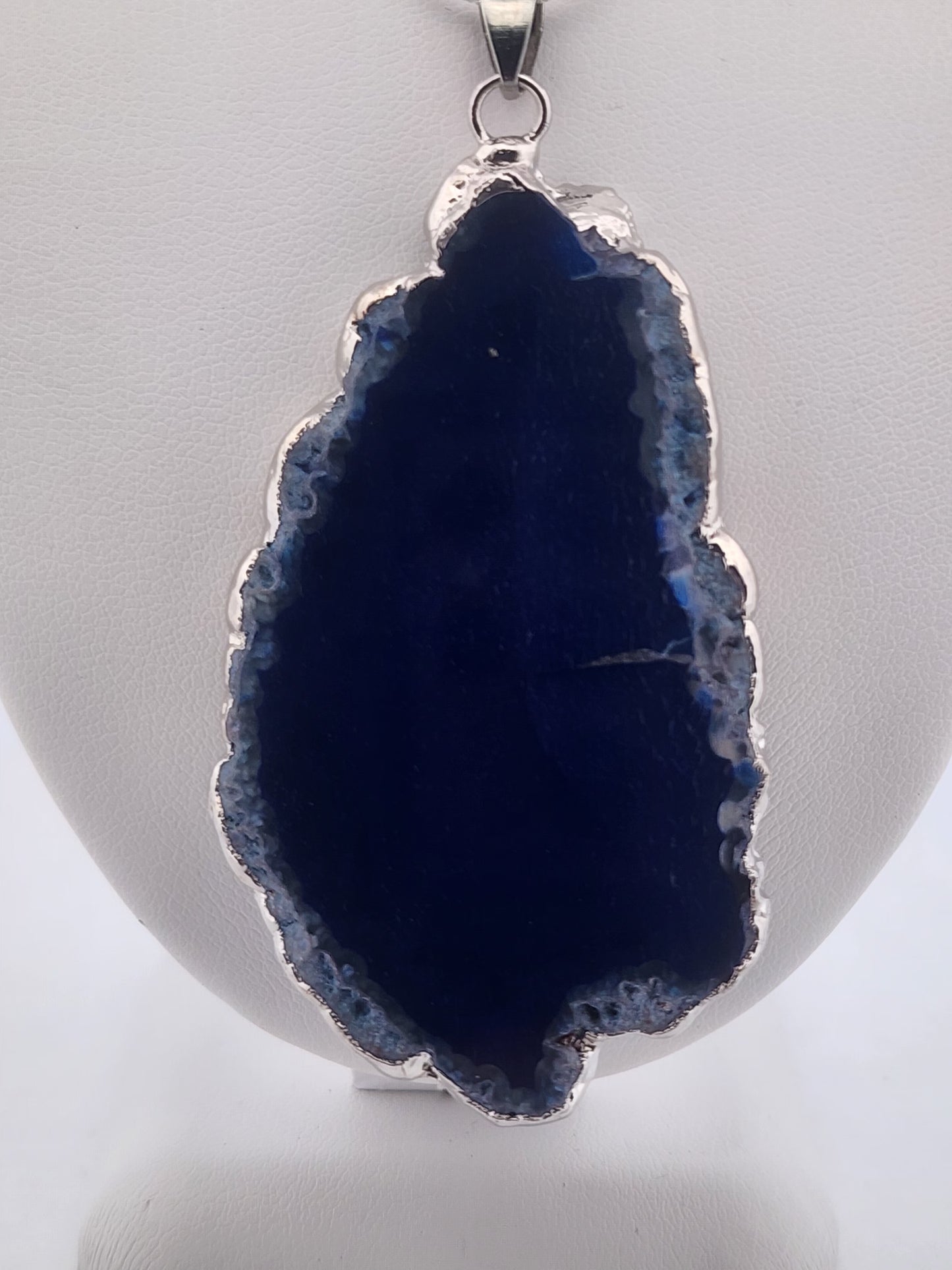 Blue geode pendant on a white background