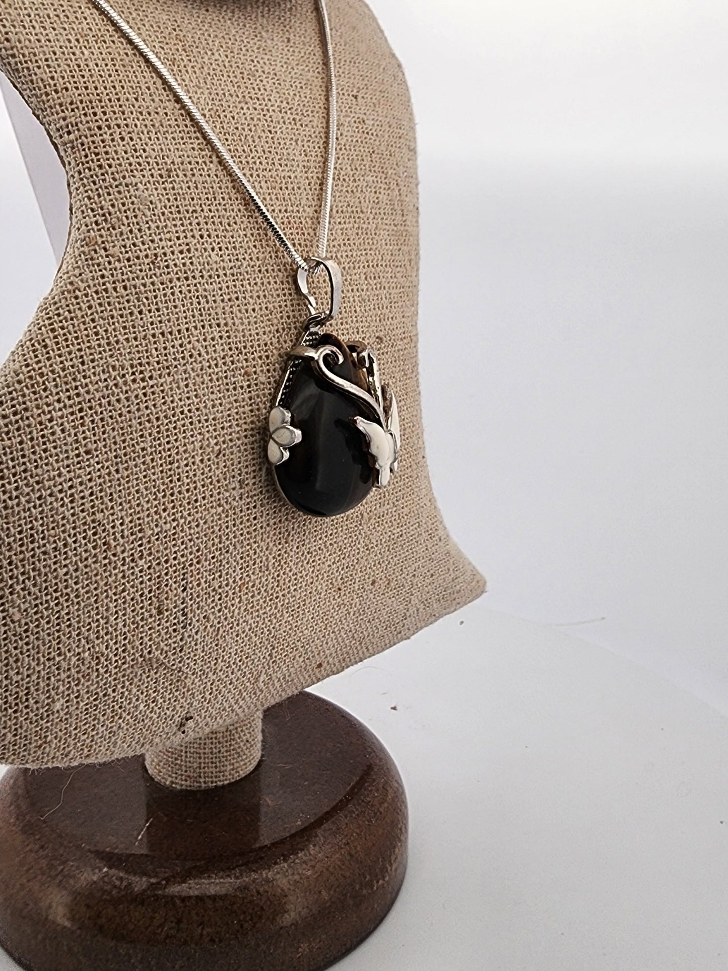Necklace with a black pendant on a mannequin bust against a white background