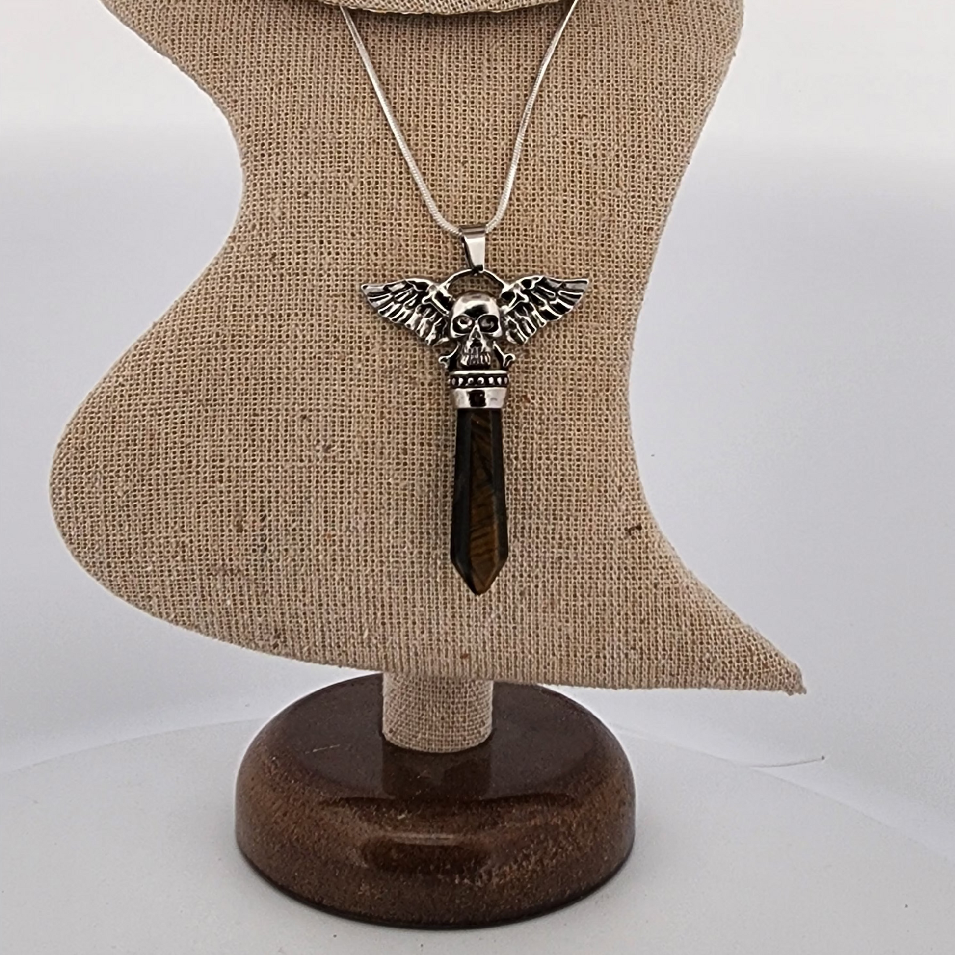 Necklace with an angel wing pendant on a mannequin bust against a white background