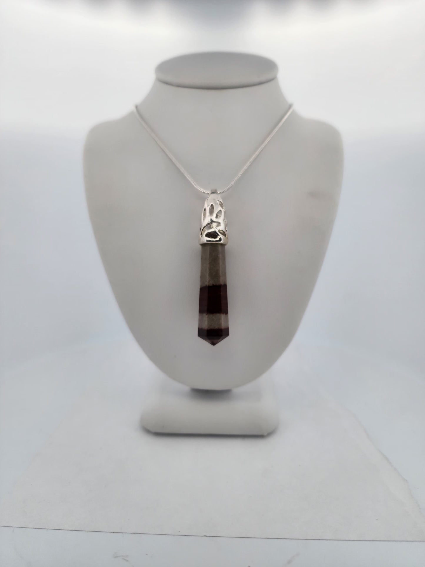 Necklace with a pendant on a mannequin bust against a white background