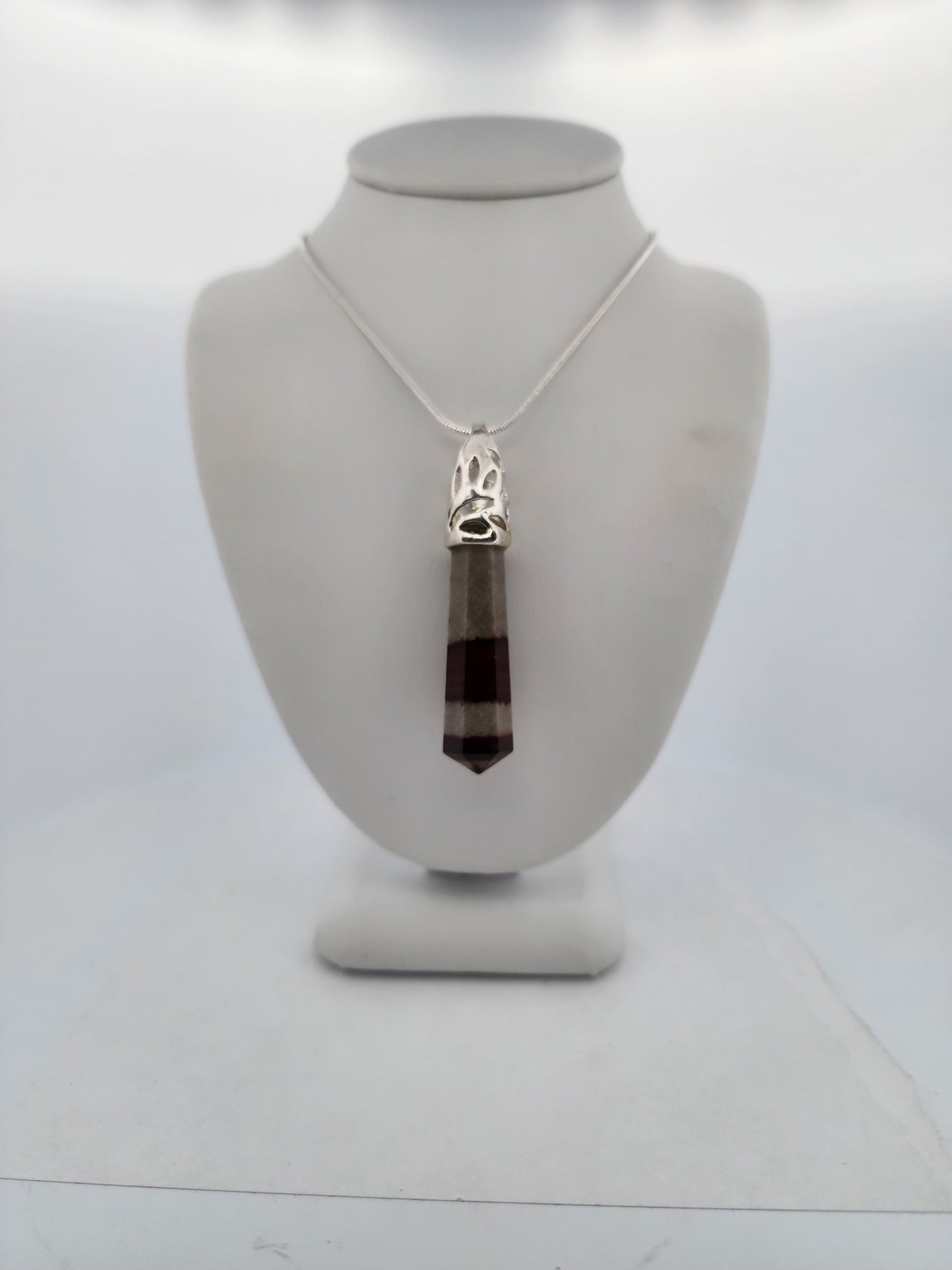 Necklace with a pendant on a mannequin bust against a white background