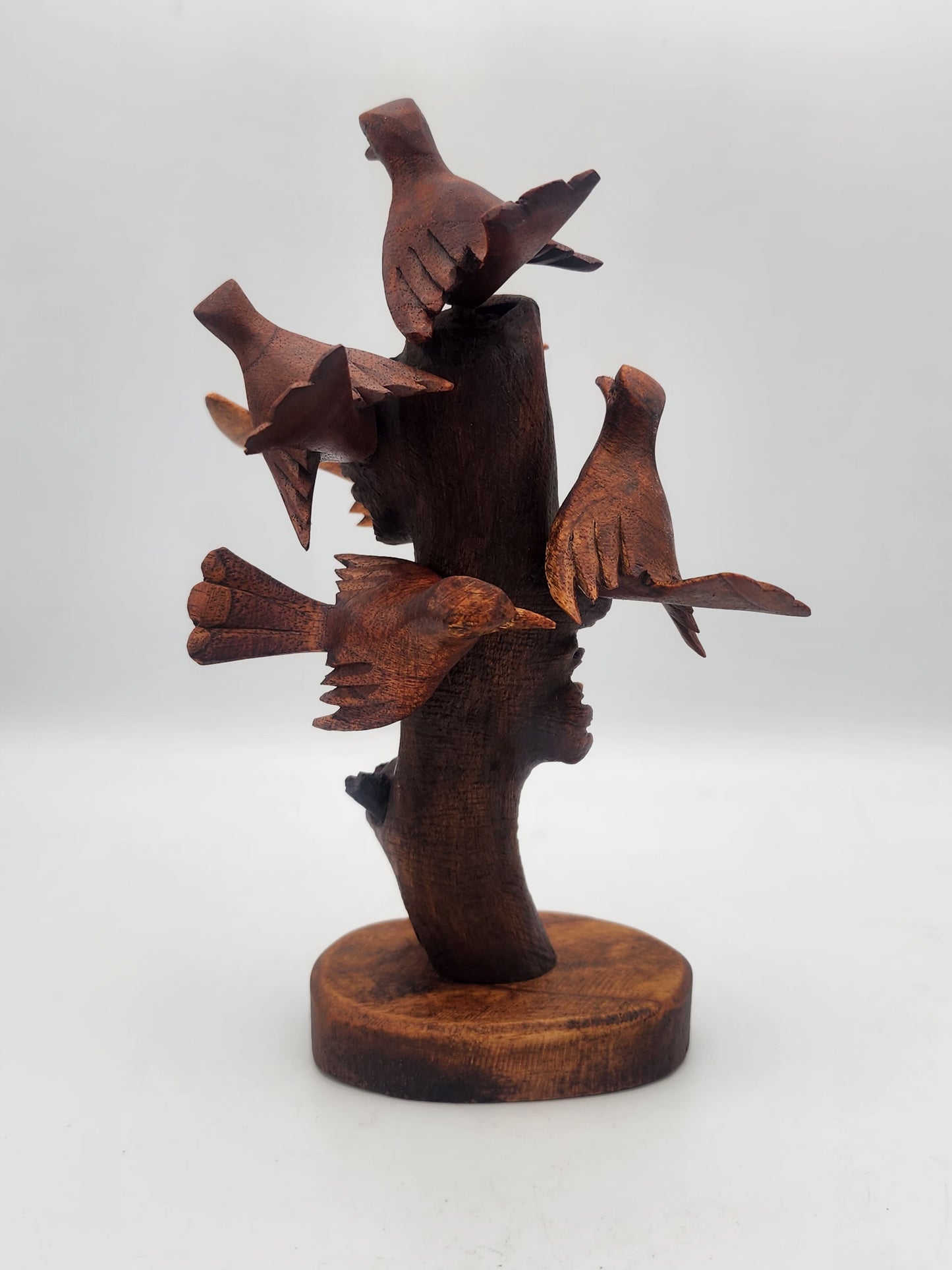 Wooden sculpture of birds on a branch with a white background