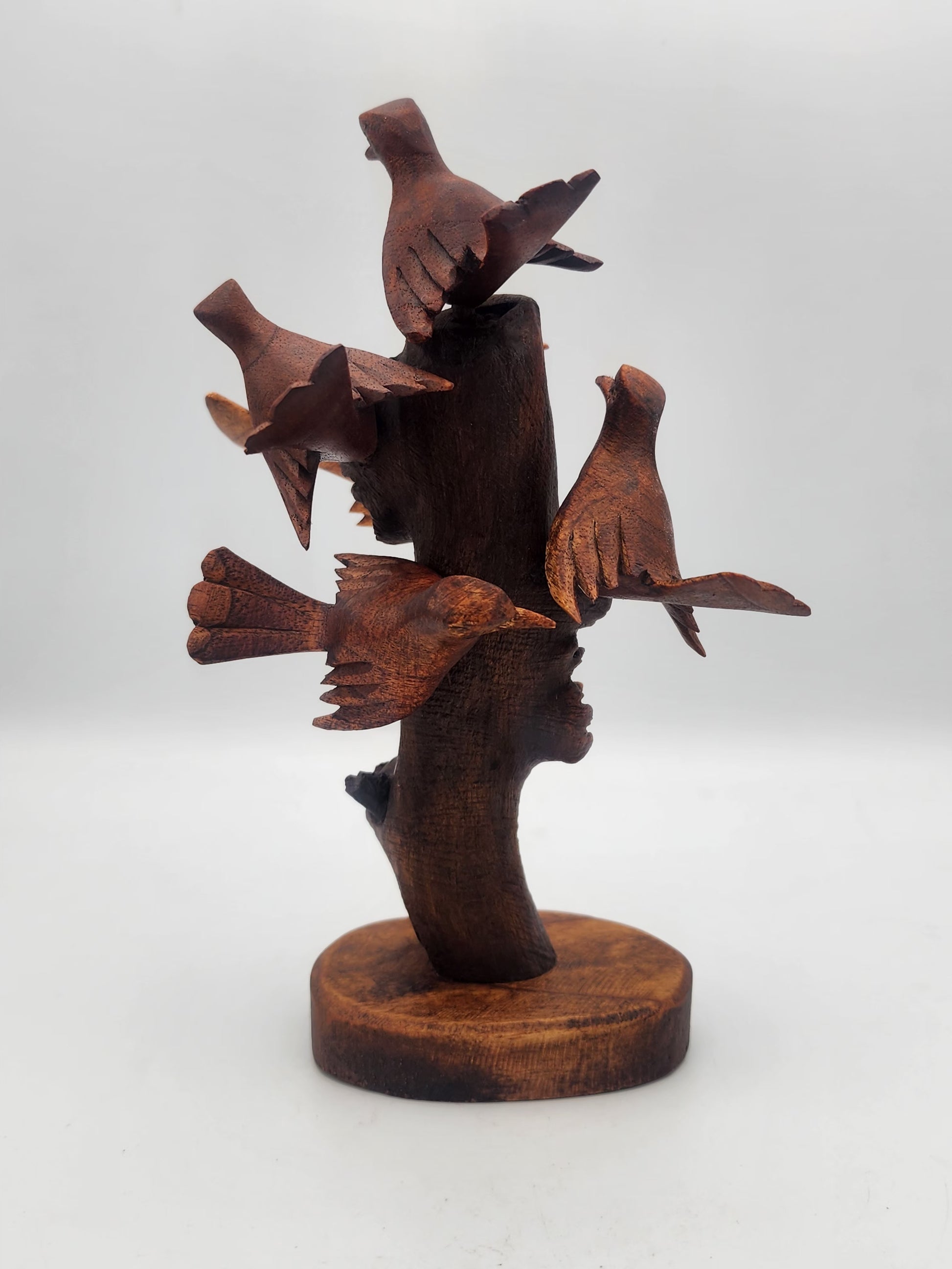 Wooden sculpture of birds on a branch with a white background