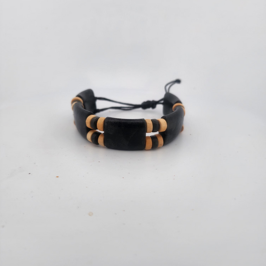 Black and gold bracelet on a light gray background