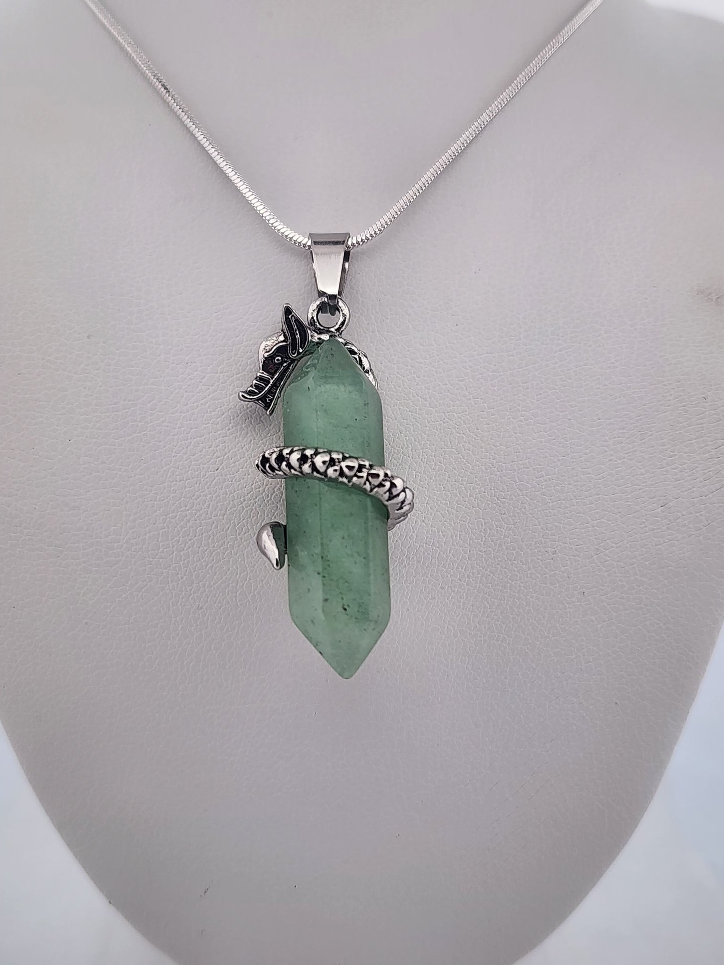 Green crystal pendant with silver chain on a white background