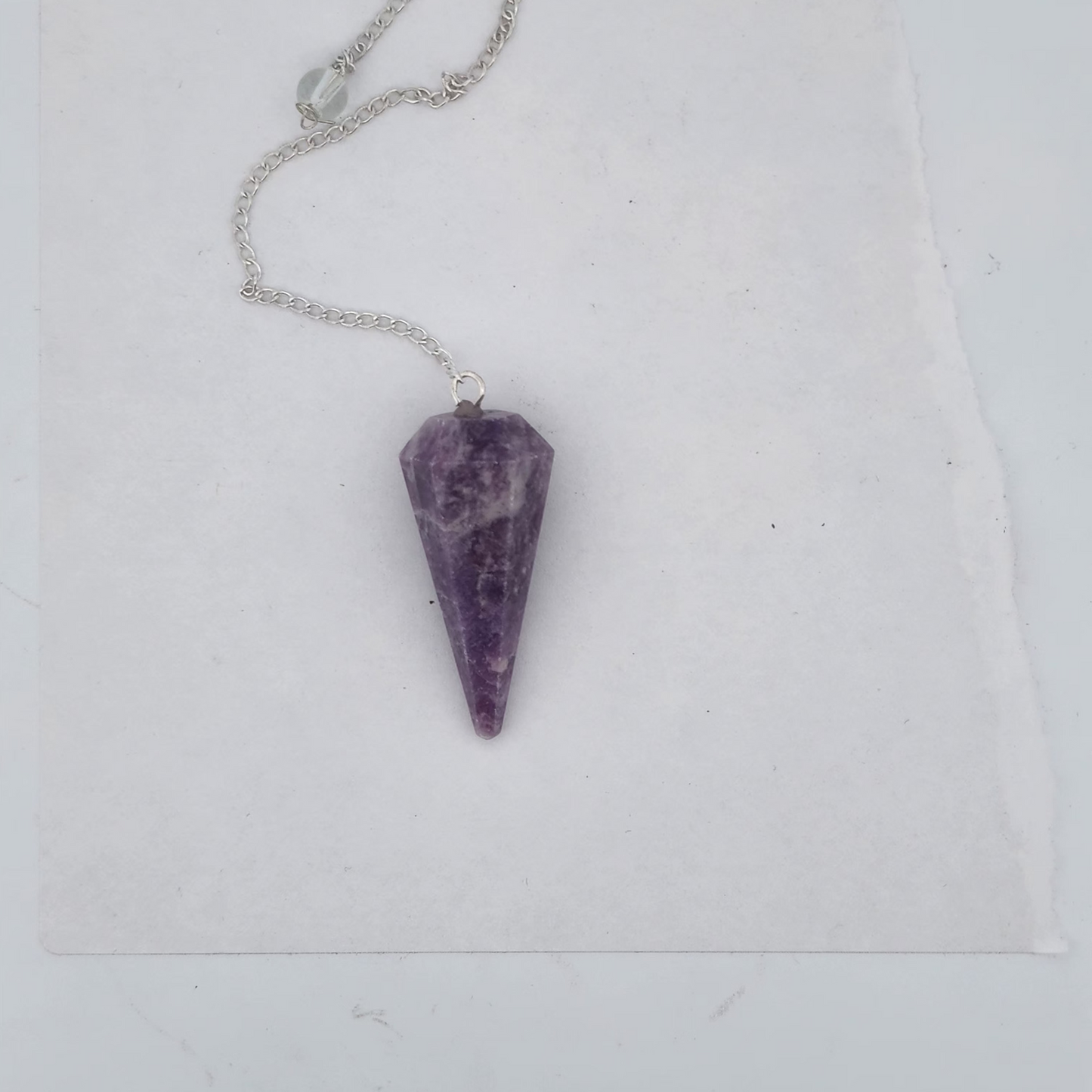 Amethyst pendulum on a white background