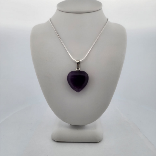Necklace with a purple heart pendant on a gray mannequin bust against a white background