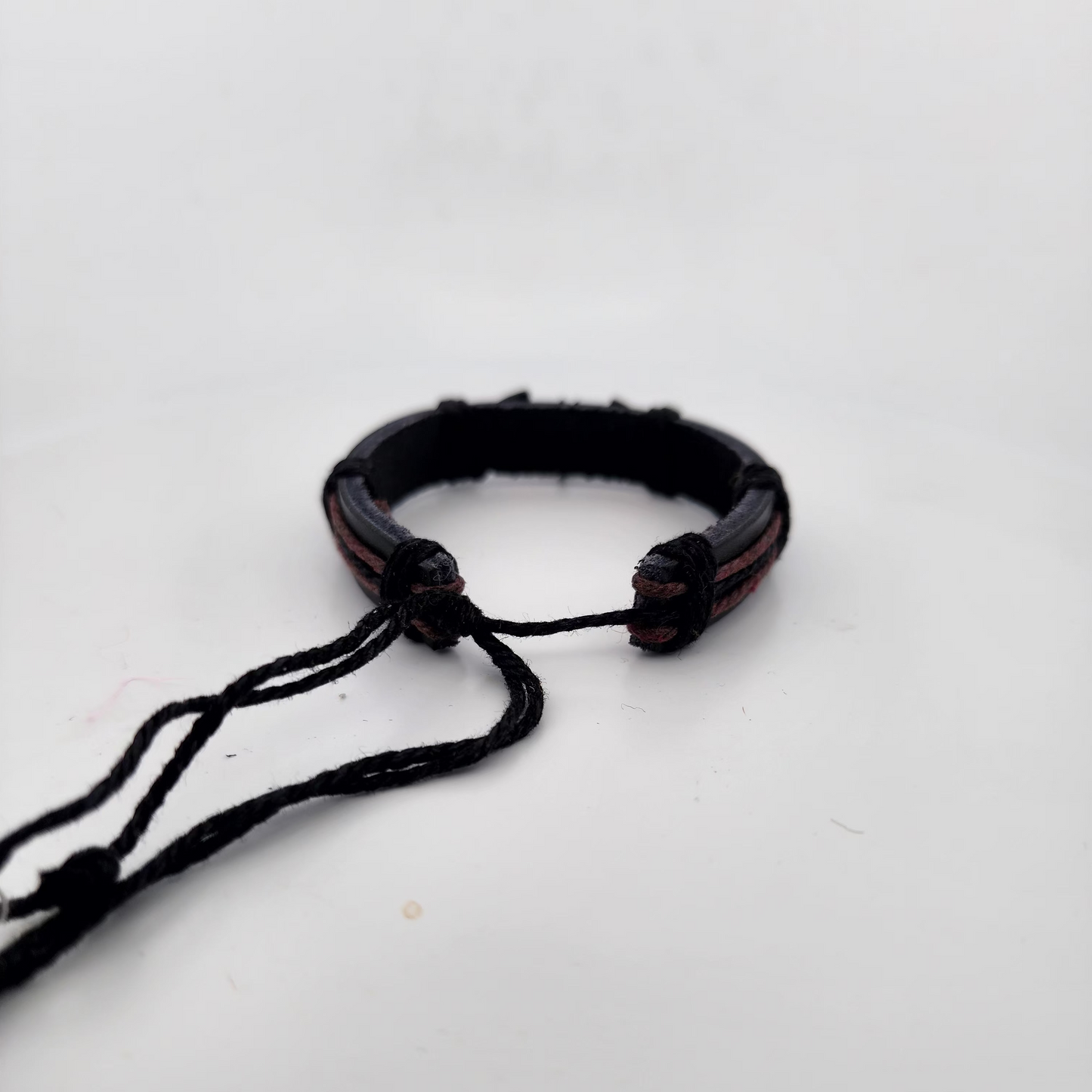 Black braided bracelet on a white background
