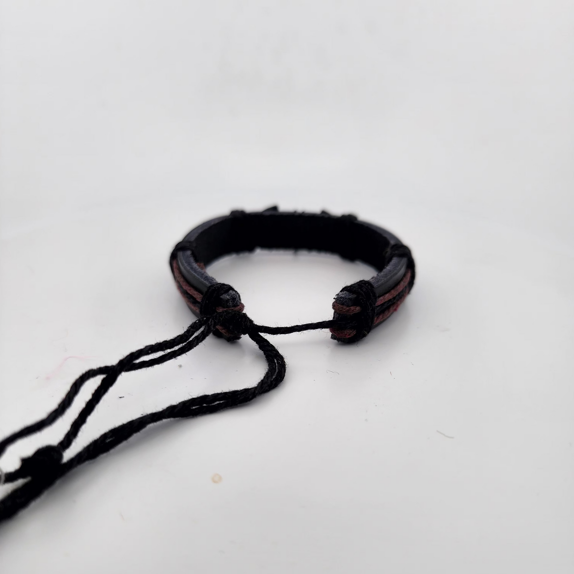 Black braided bracelet on a white background