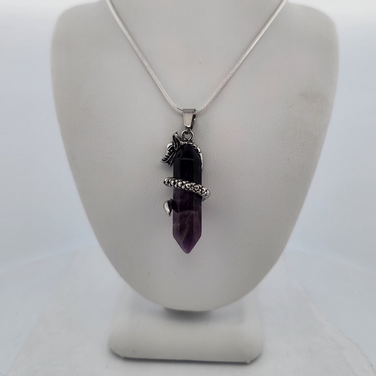 Necklace with a purple pendant on a white stand against a white background