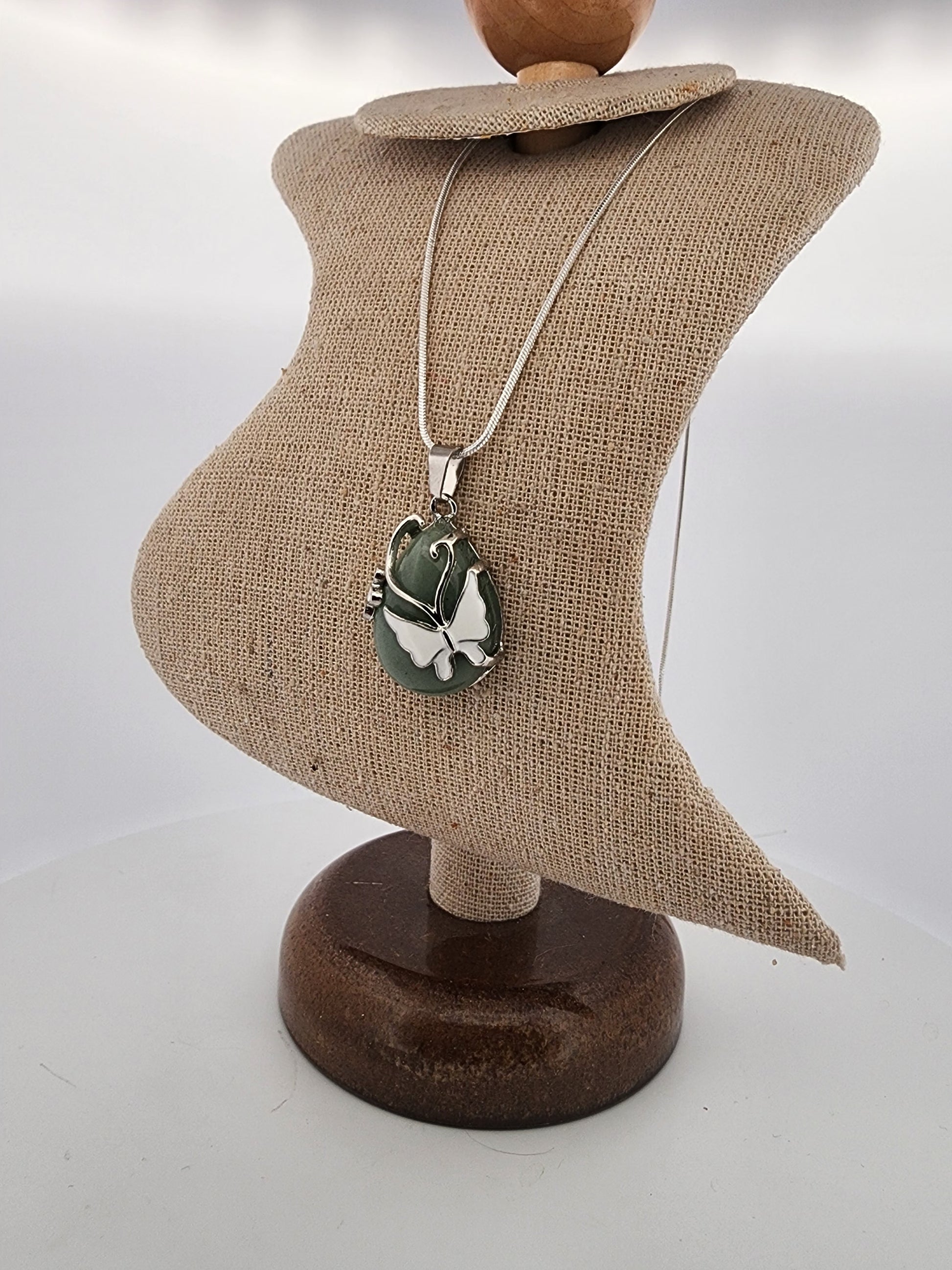 Necklace with a pendant on a mannequin bust against a plain background