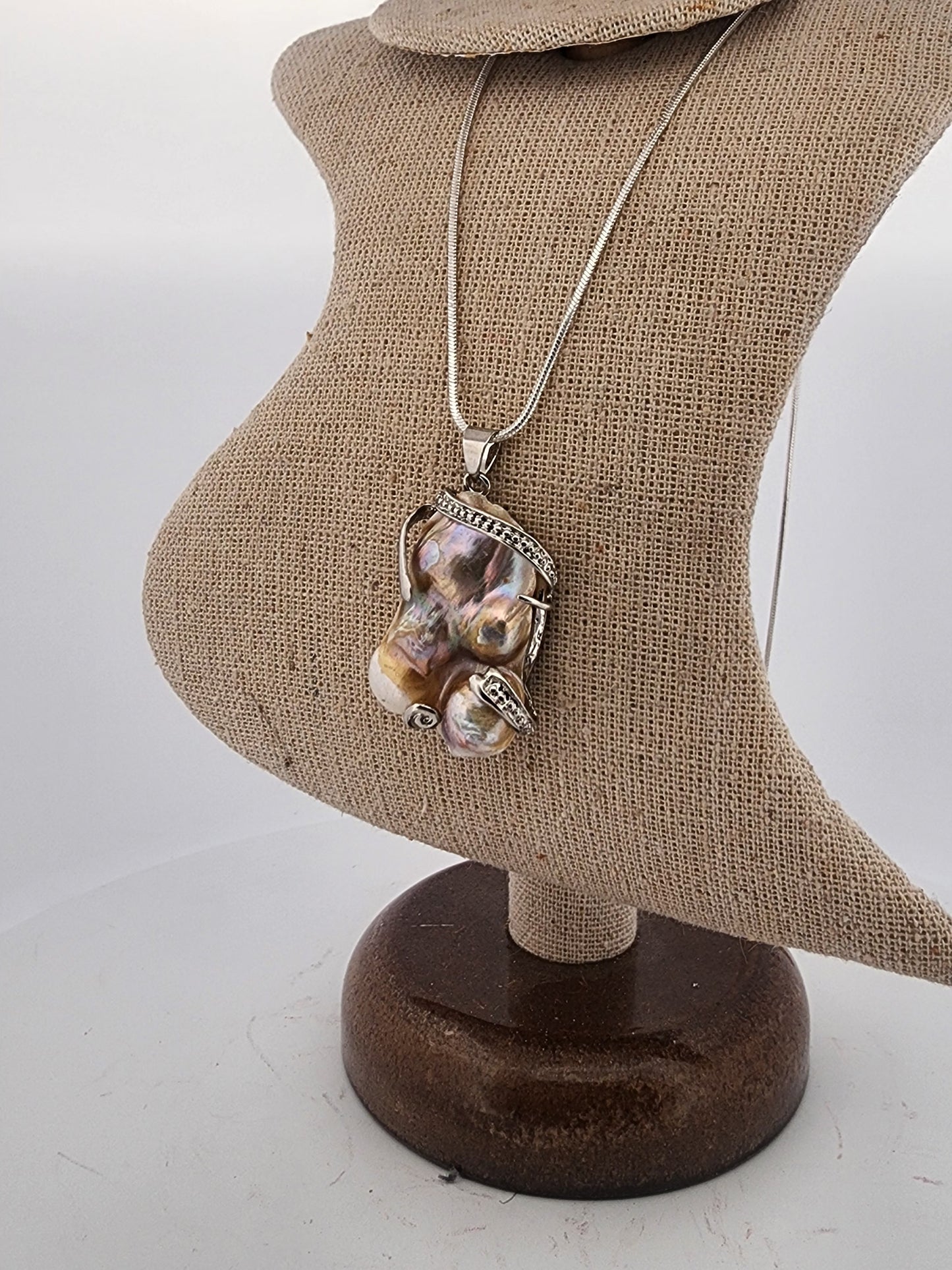 Necklace with a large pendant on a mannequin bust against a white background