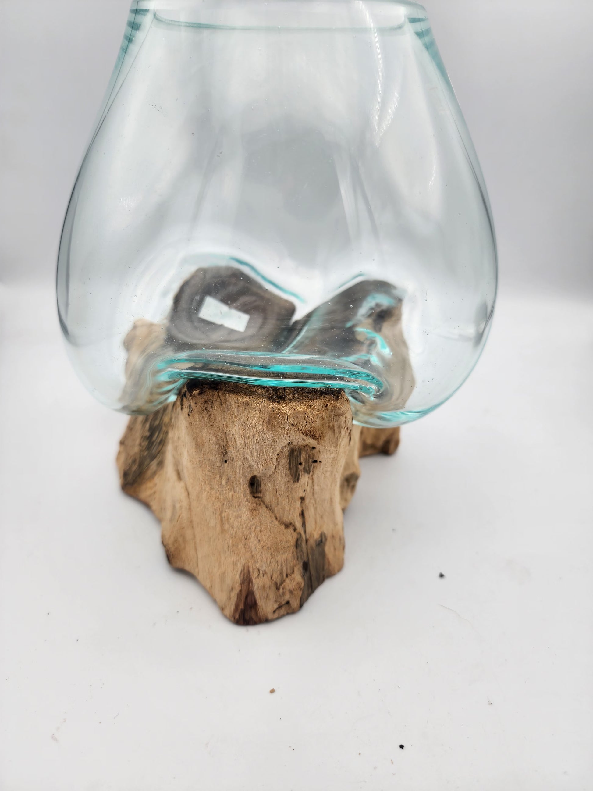 Glass container on a wooden block against a white background