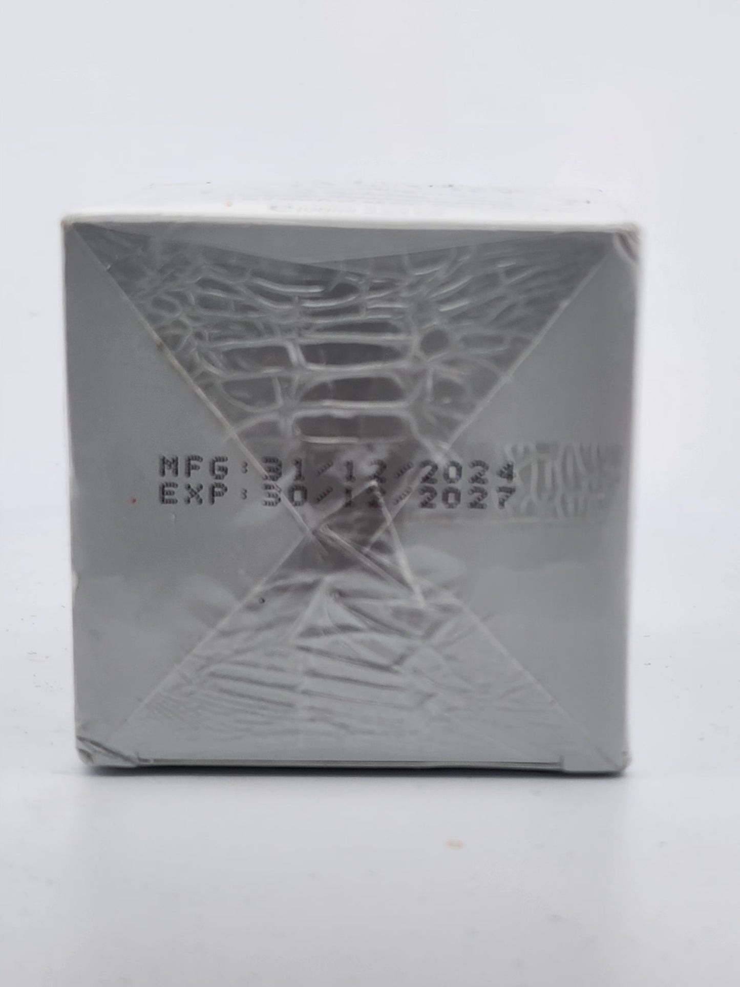 Silver product packaging with embossed design and text on a white background