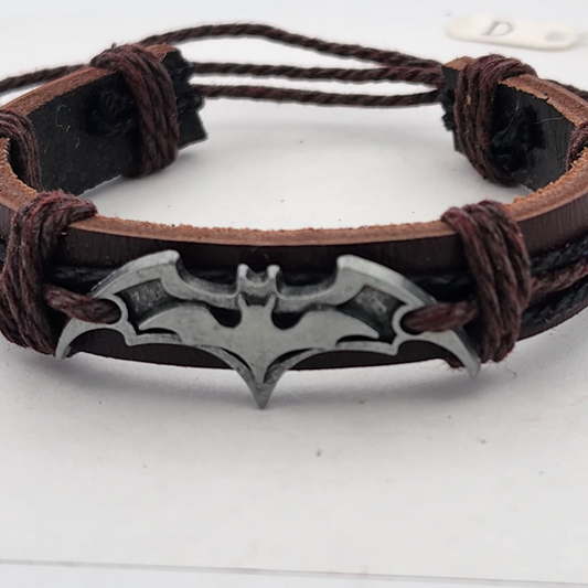 Brown leather bracelet with a silver bat-shaped pendant on a white background