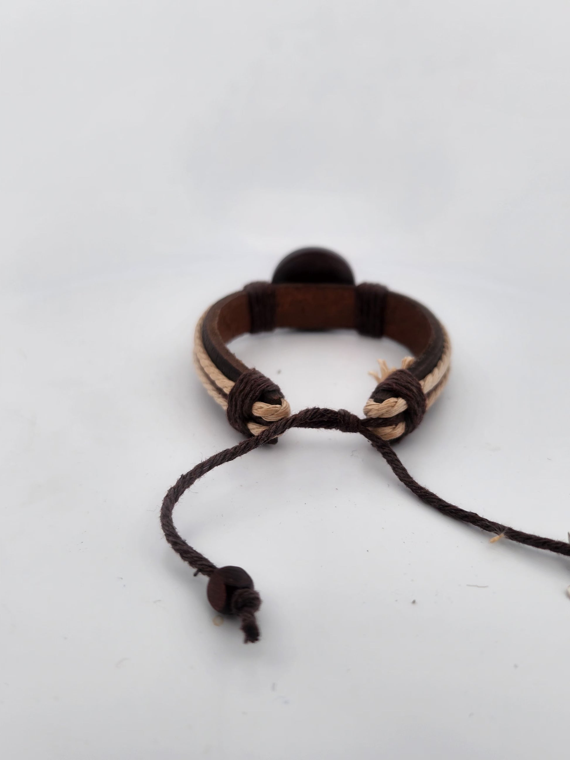 Bracelet with brown and beige cord on a white background