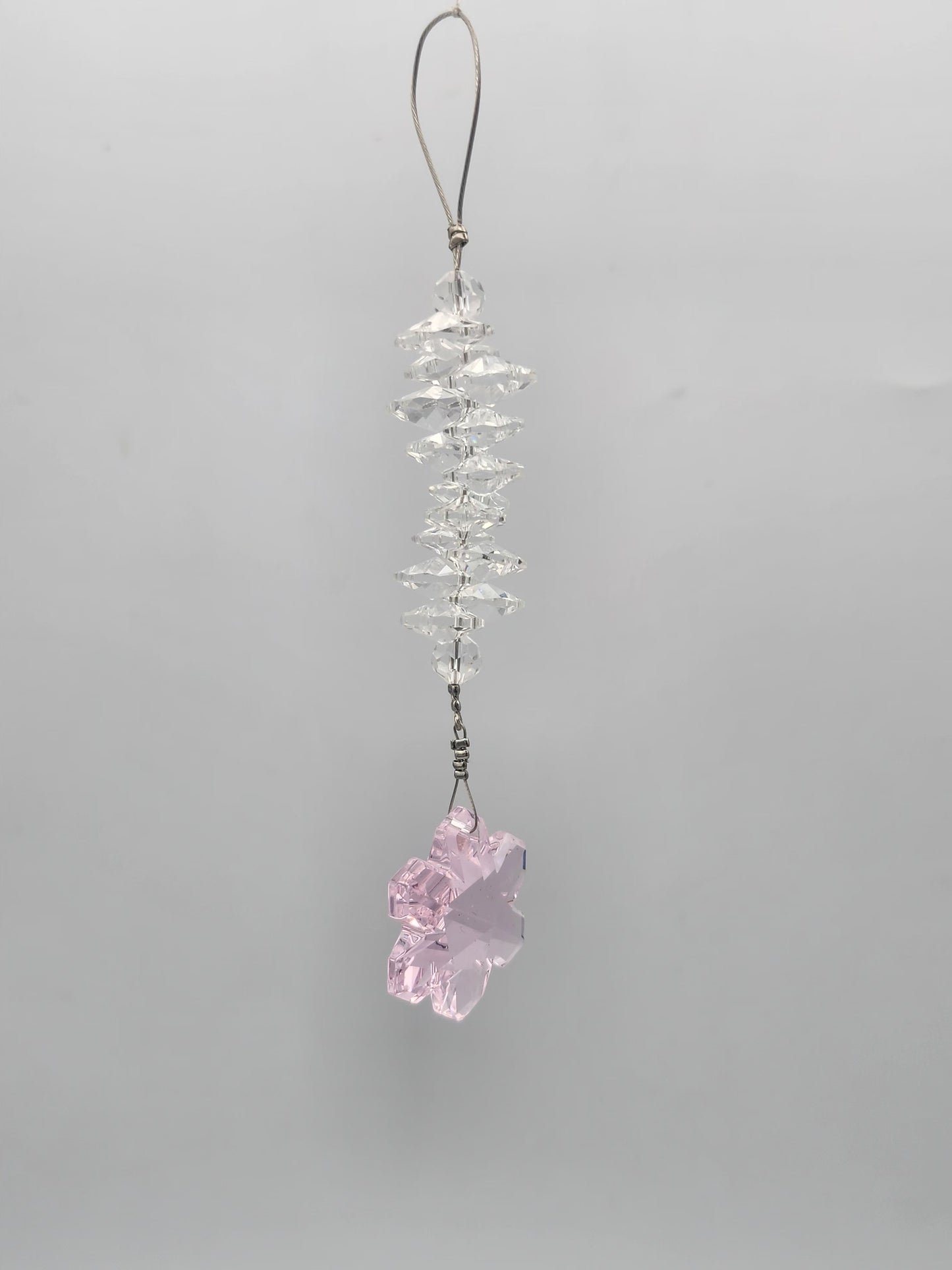 Crystal phone charm with a pink crystal on a gray background