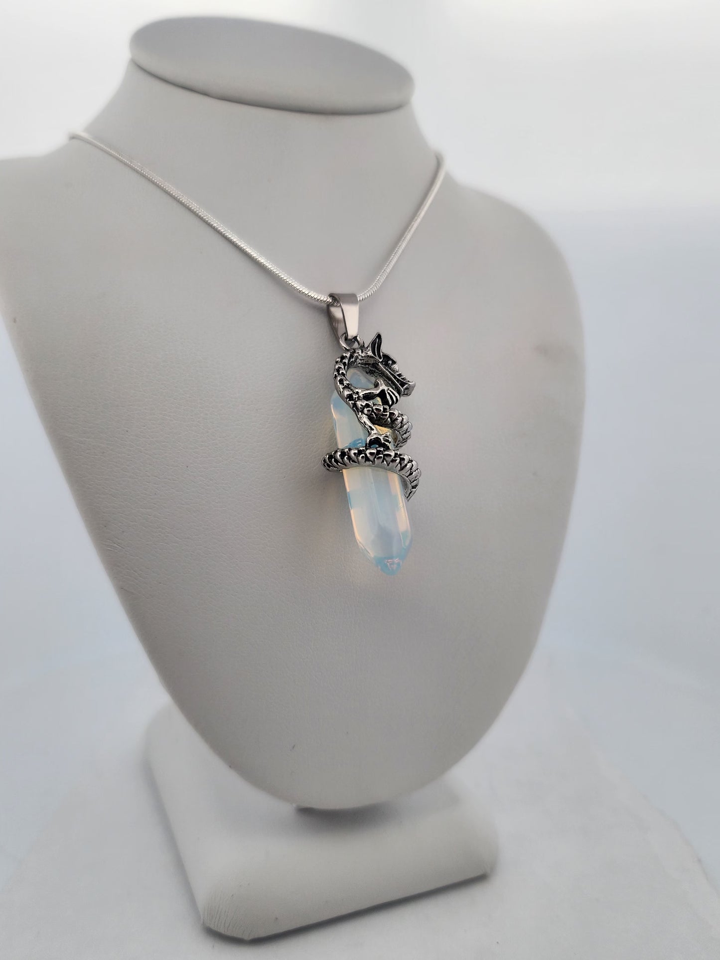 Necklace with a pendant on a gray stand against a white background