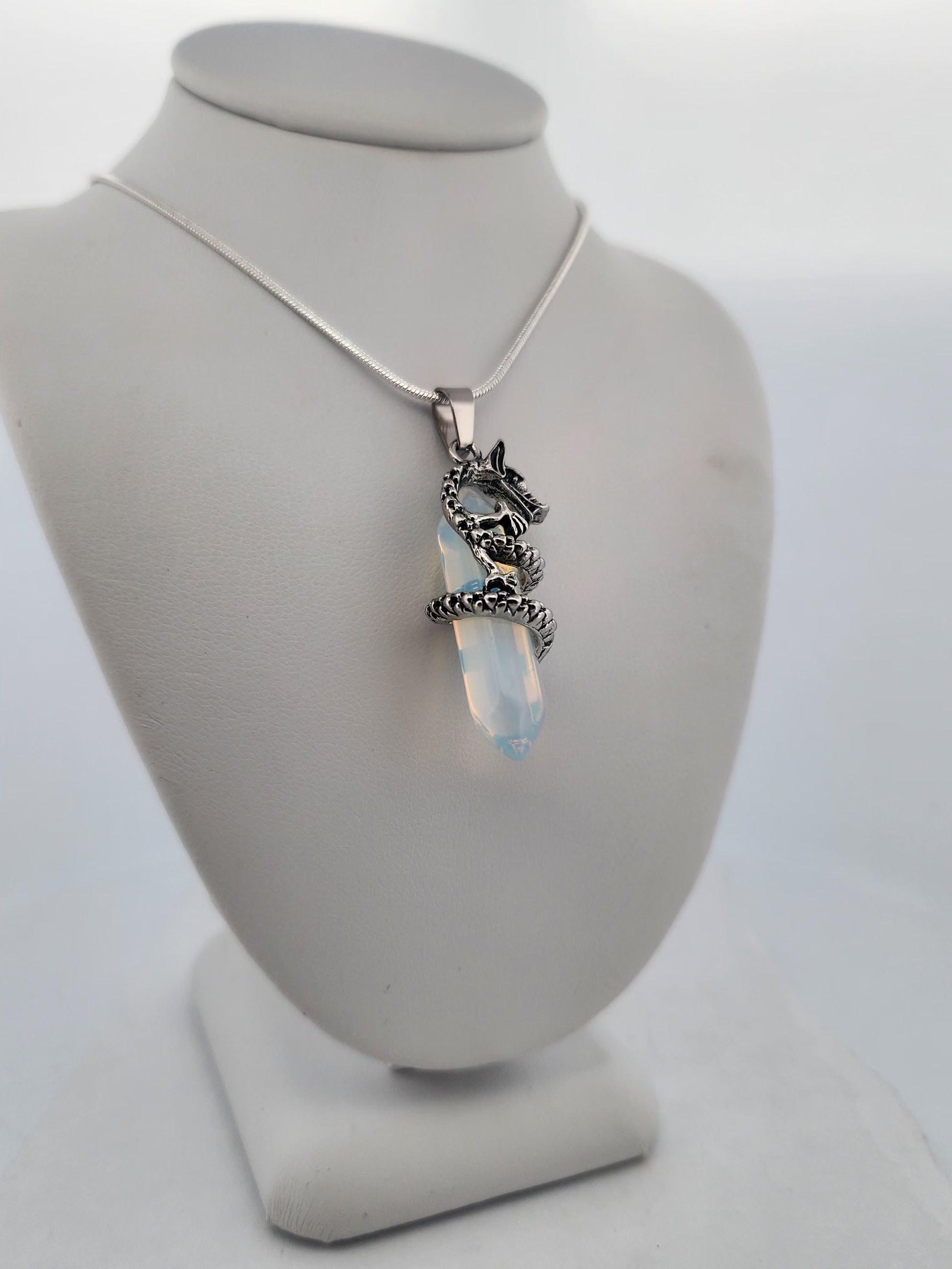 Necklace with a pendant on a gray stand against a white background