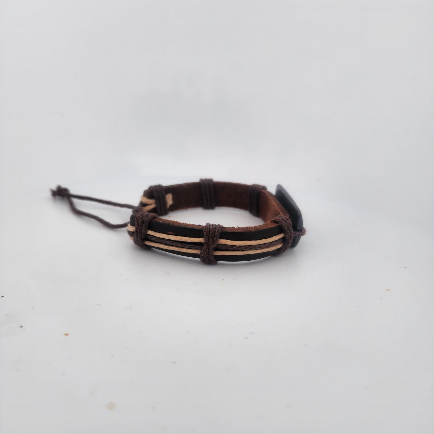 Bracelet with brown leather strap and metal loops on a white background