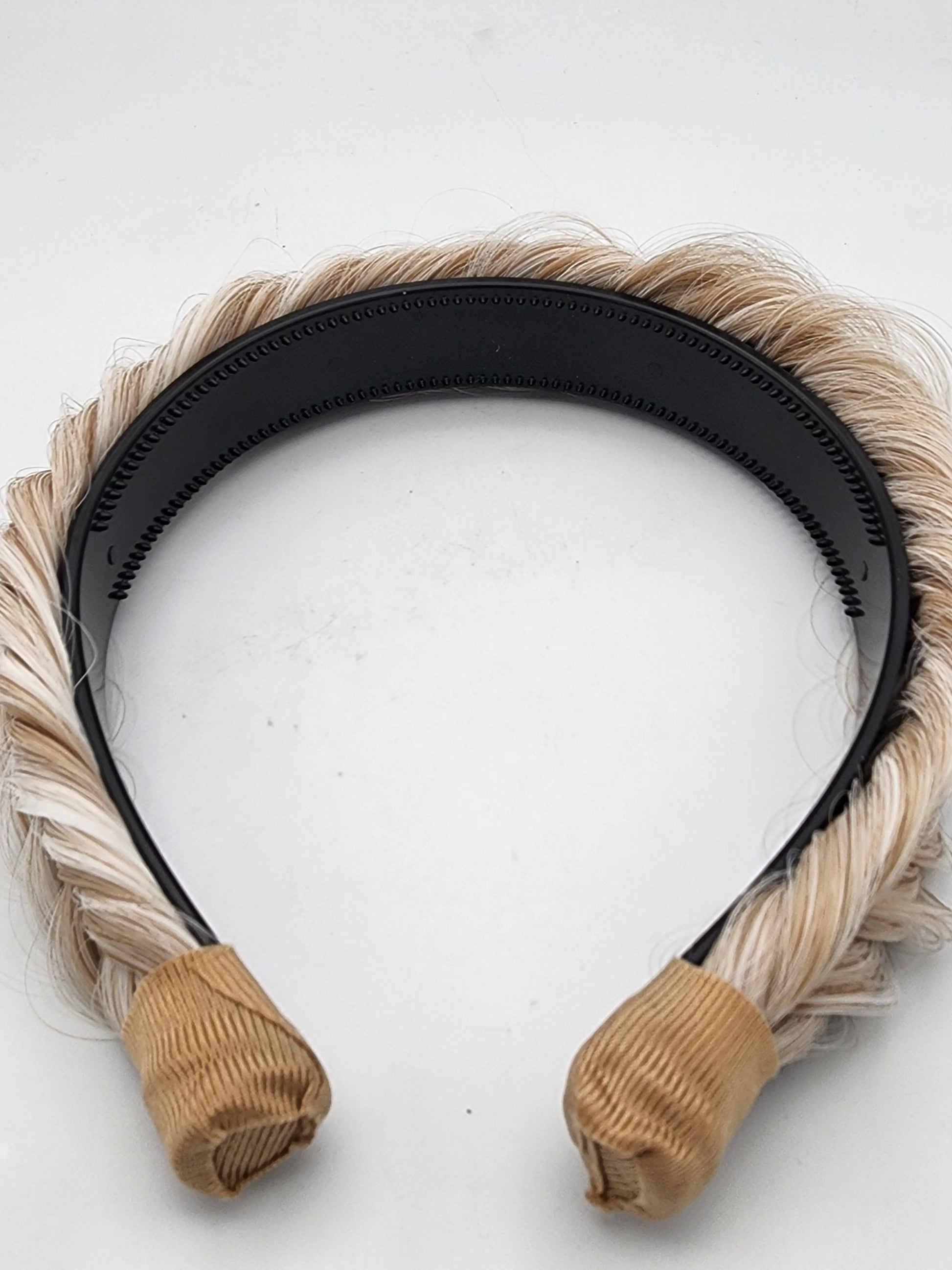 Black headband with beige hair extensions on a white background