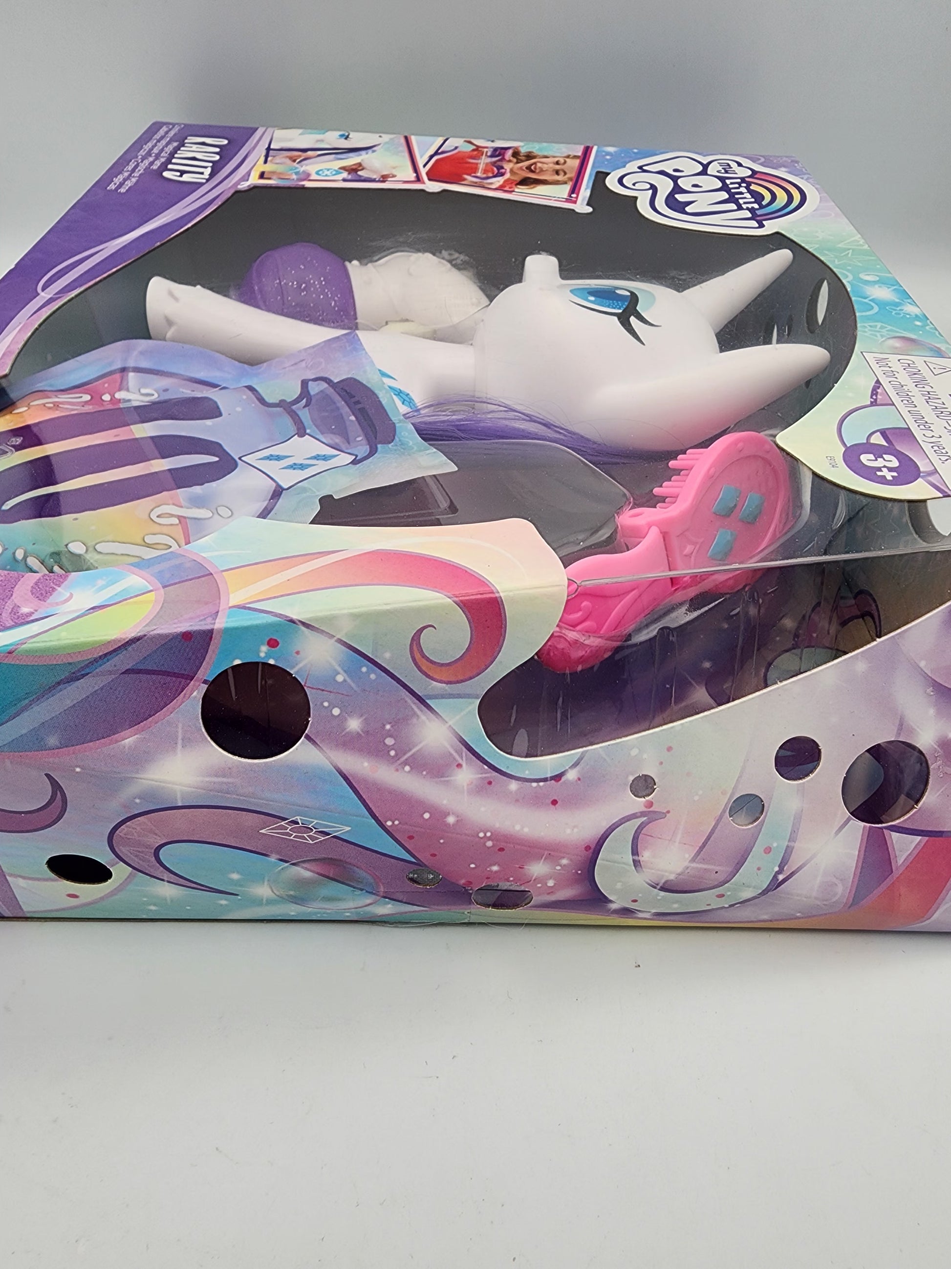 Toy figure of a unicorn in a colorful box on a white background