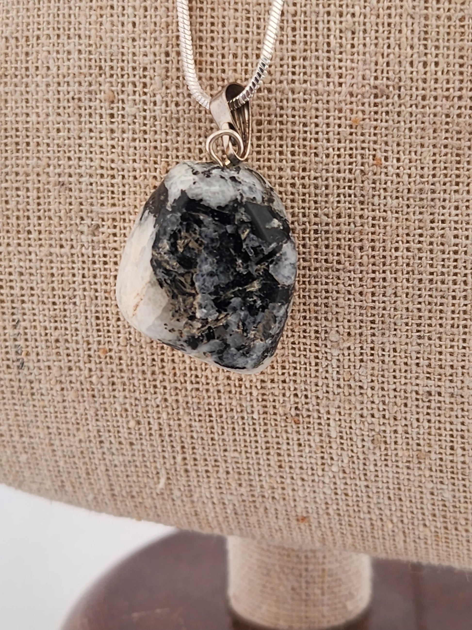 Necklace with a pendant featuring a rough, natural stone on a burlap background