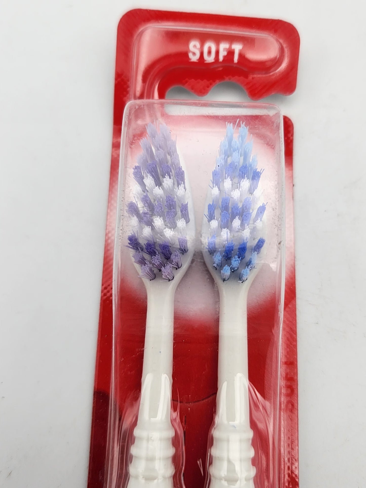 Two toothbrushes with soft bristles in a red packaging