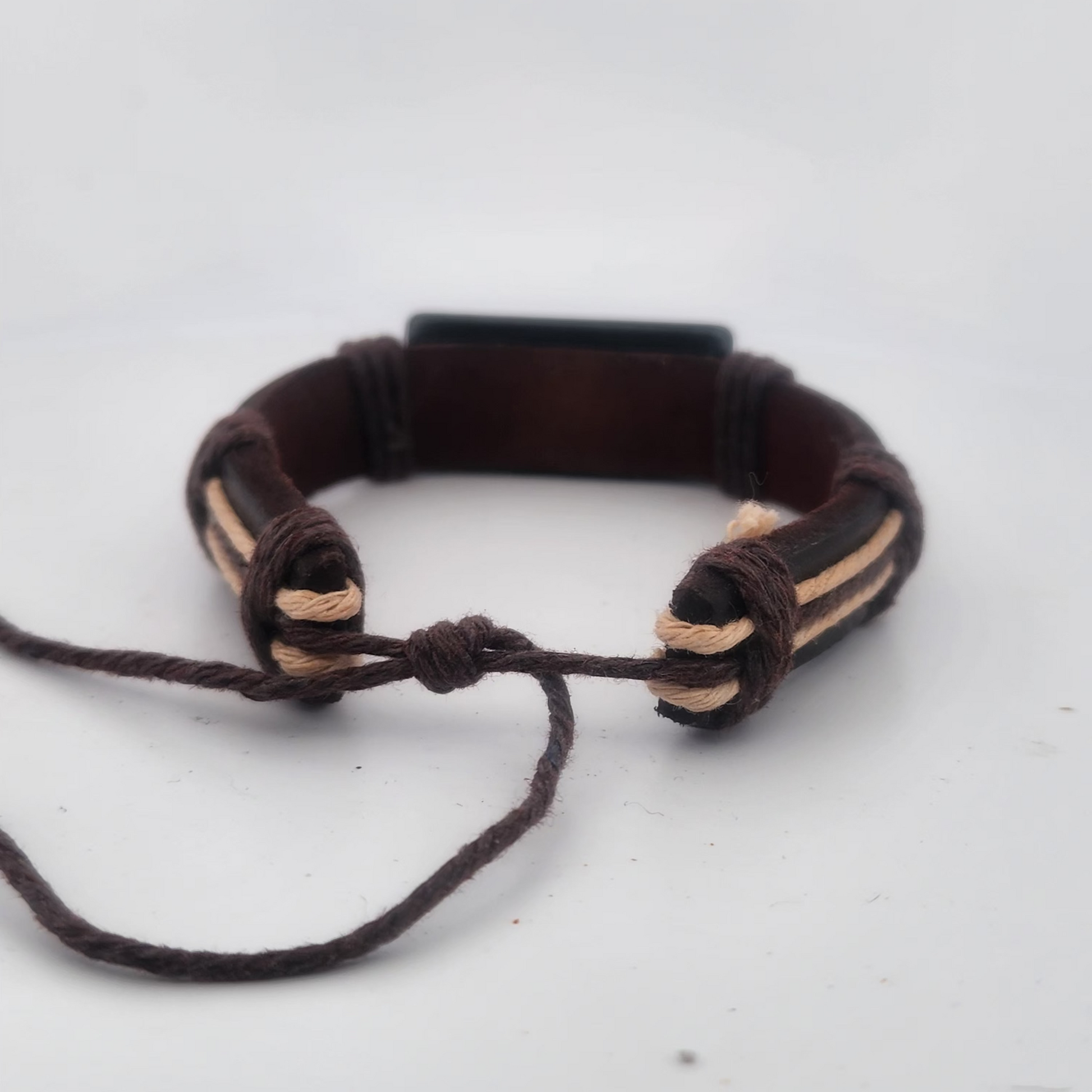 Brown braided bracelet on a white background