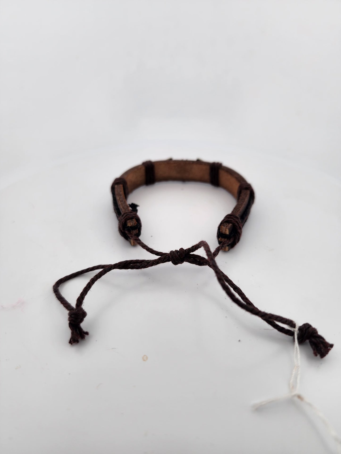 Brown leather bracelet with a knot on a white background