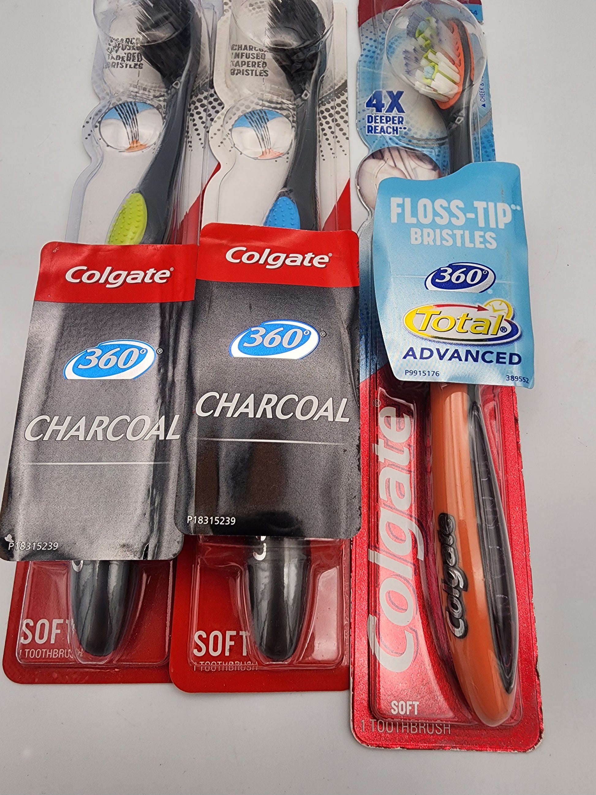 Colgate toothbrushes with packaging on a gray background