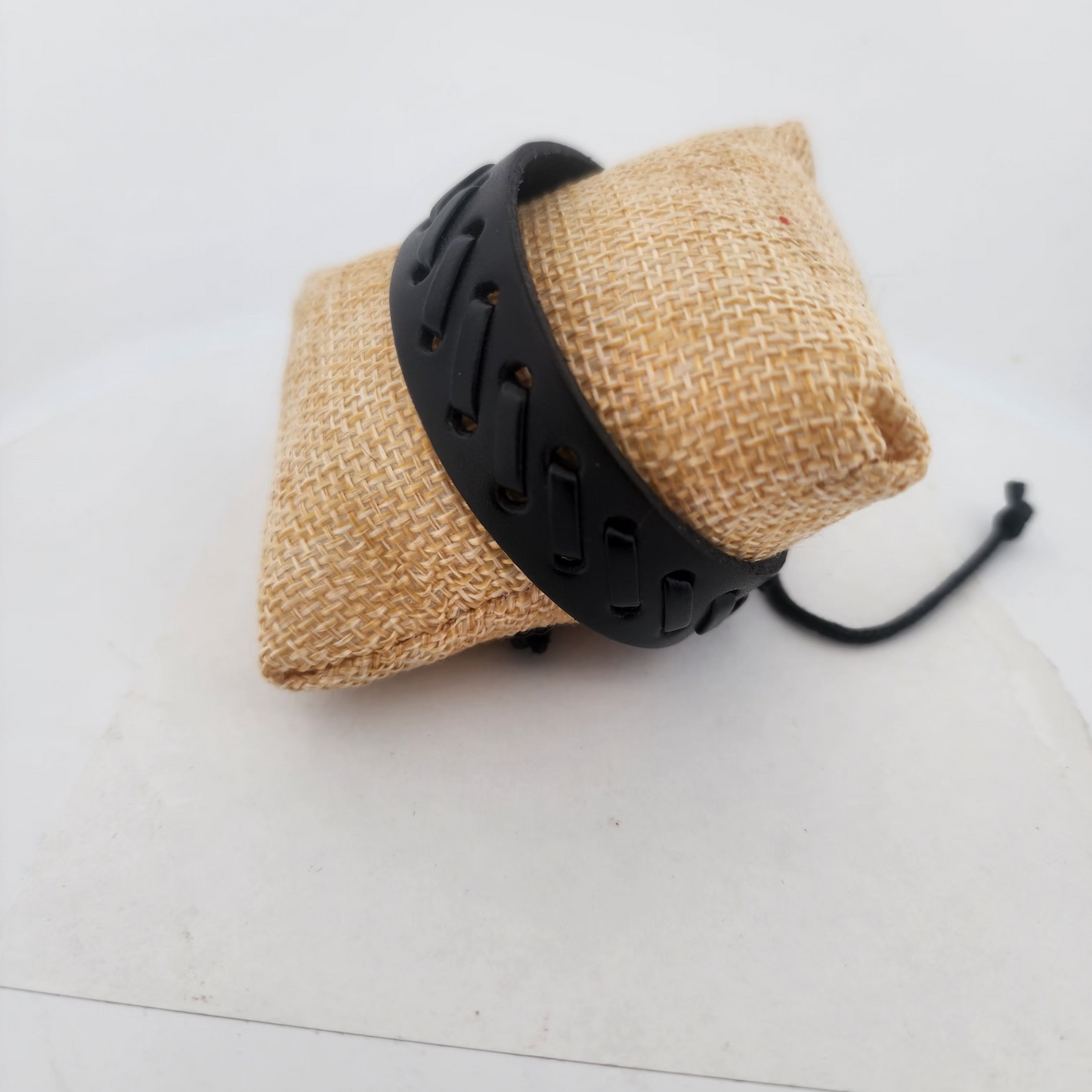 Black leather dog collar with a textured finish on a white background