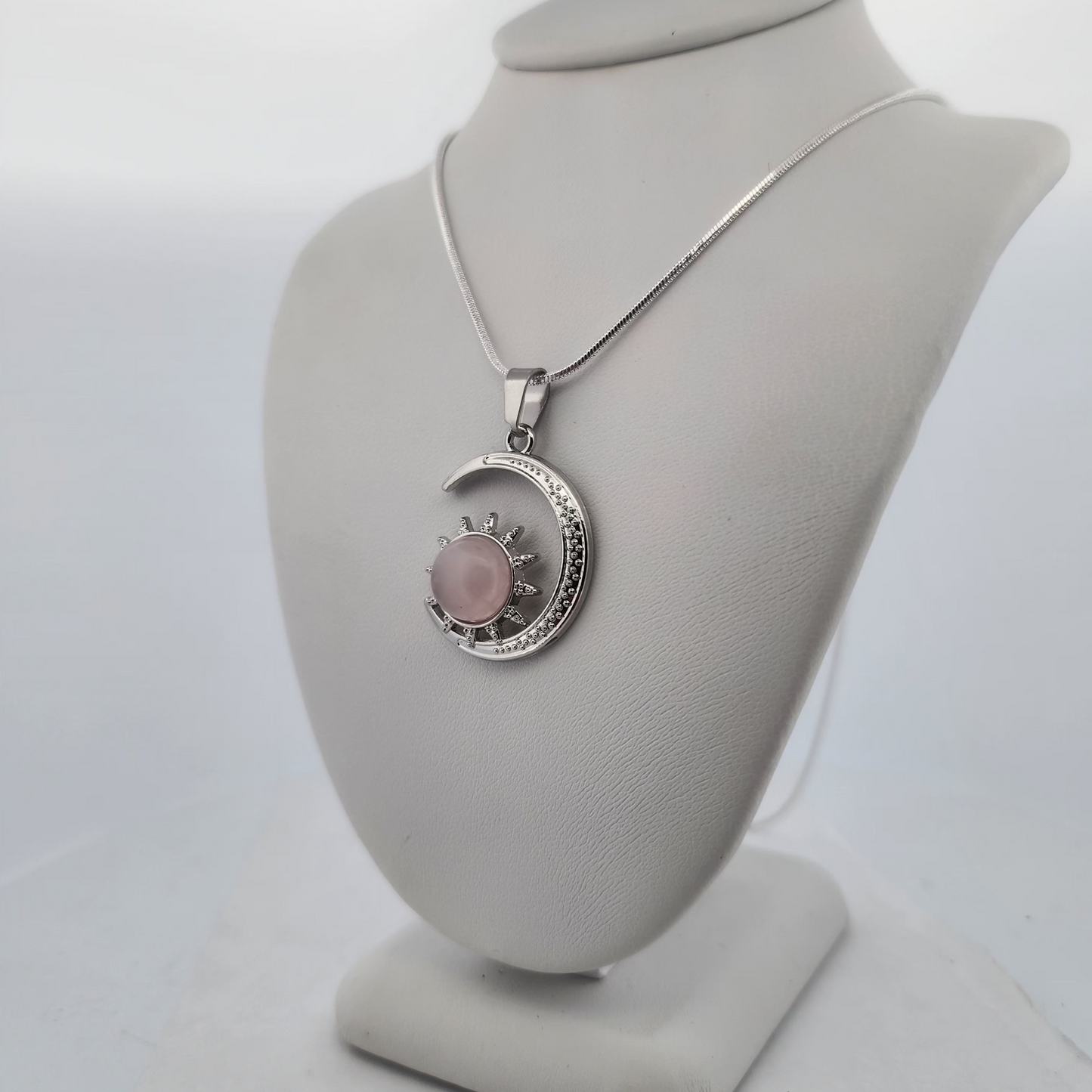 Necklace with a pink pendant on a gray bust