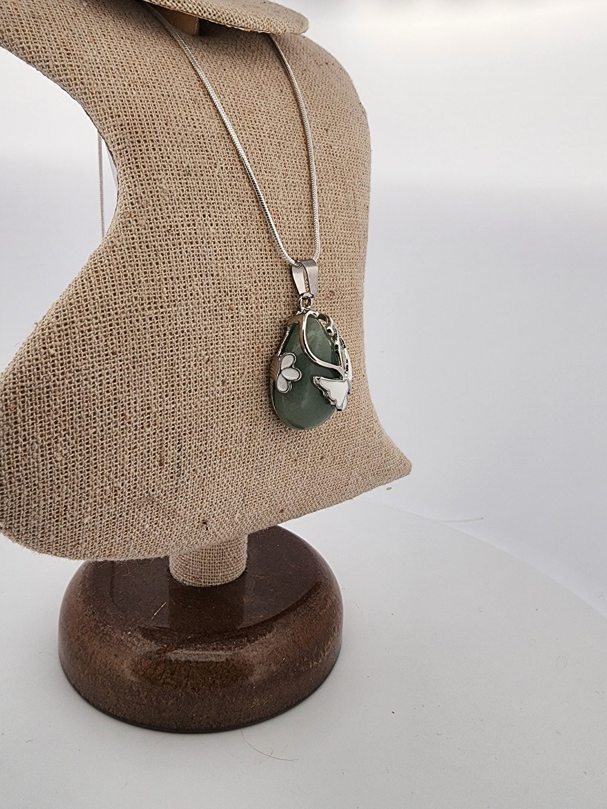 Necklace with a green pendant on a mannequin bust against a white background
