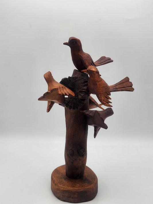 Wooden sculpture of birds on a branch with a star on a white background