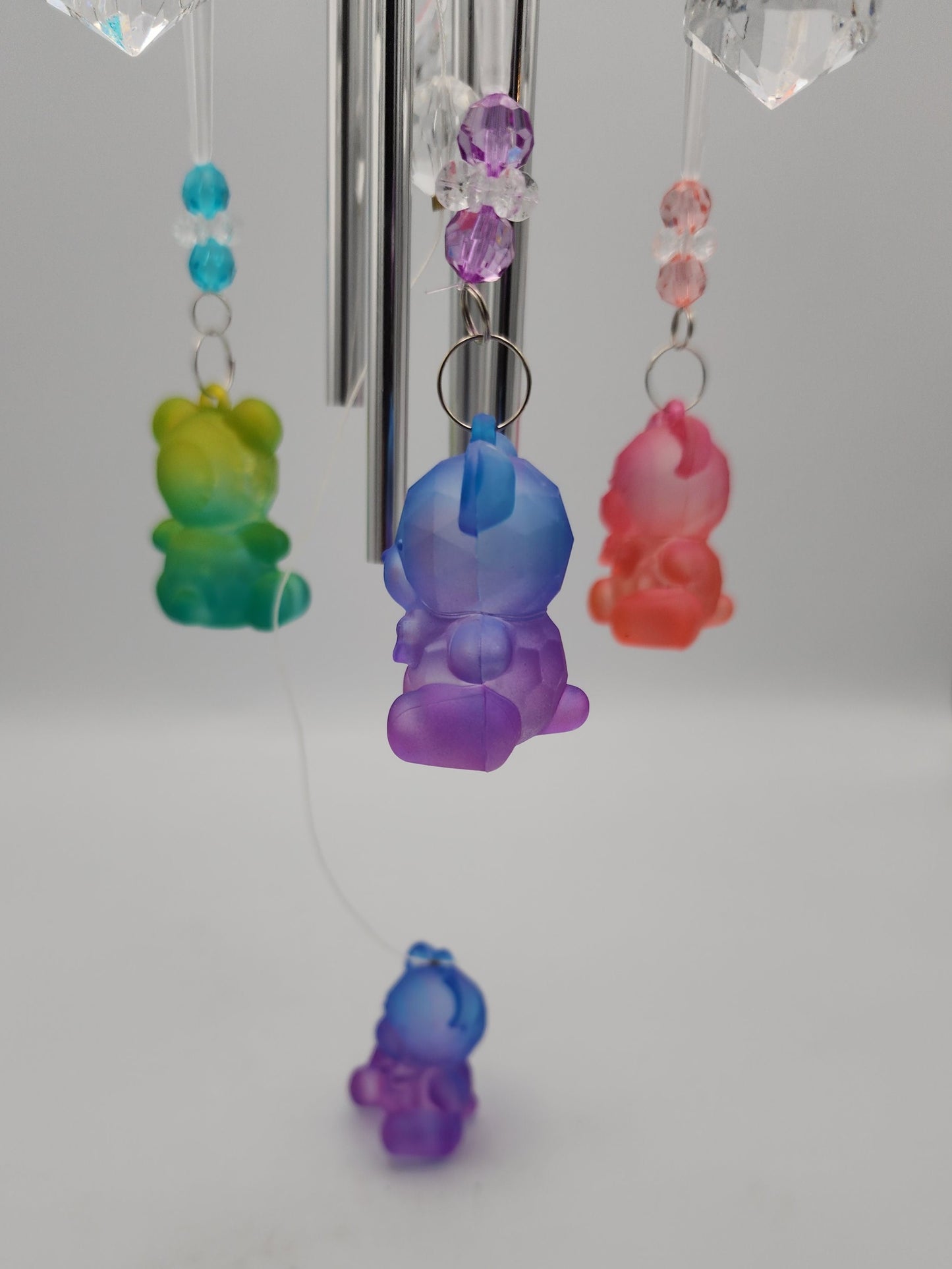 Colorful glass bear-shaped decorations on a white wall
