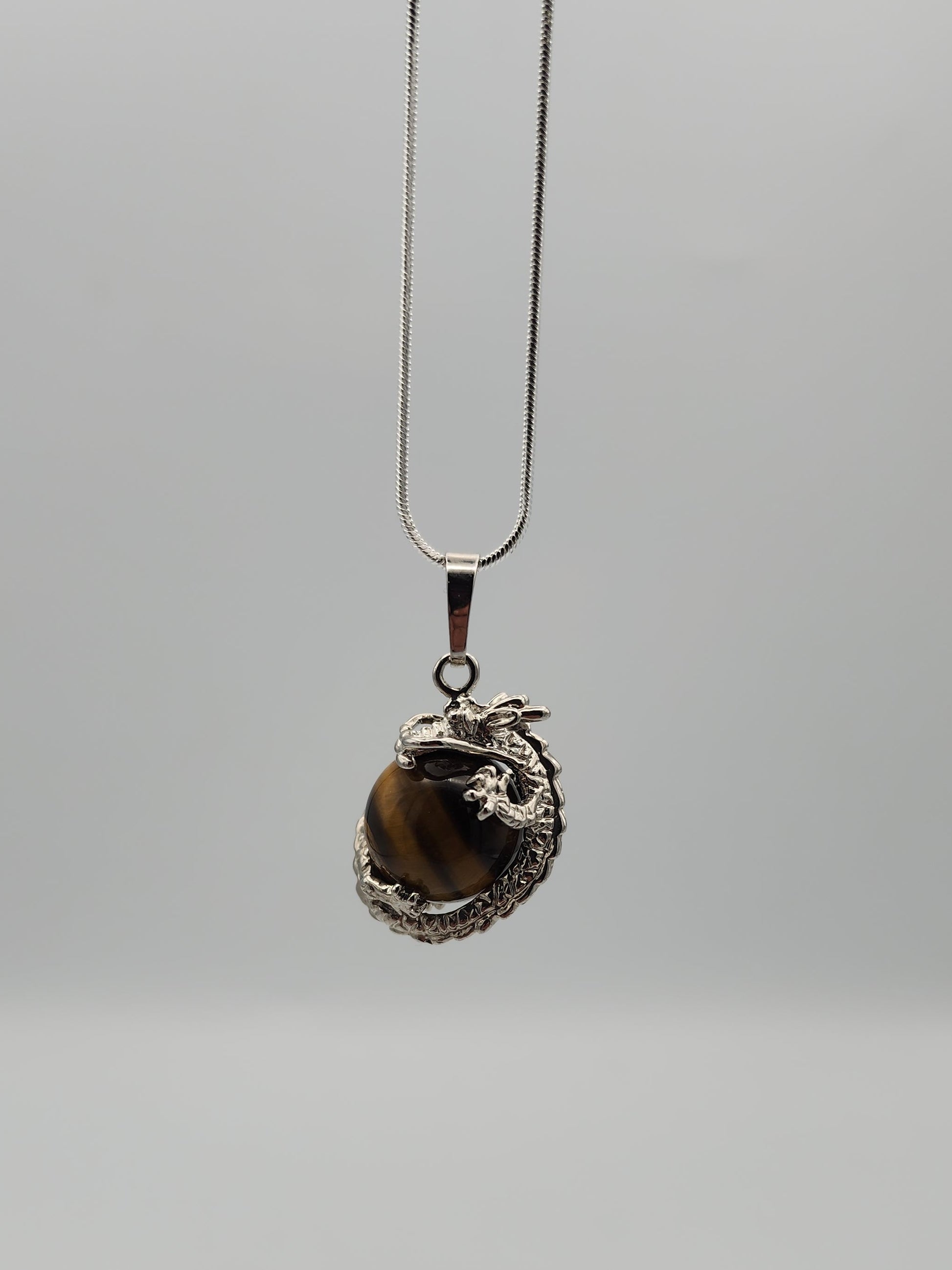 Necklace with a pendant featuring a tiger's eye stone on a gray background