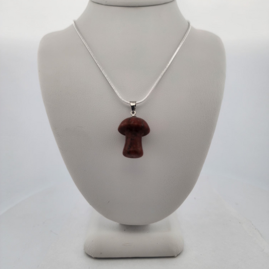 Necklace with a red pendant on a white mannequin bust against a white background